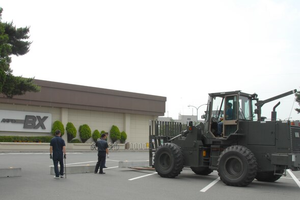 MISAWA AIR BASE, Japan -- Contractors from 35th LRS set up barrier engagements outside the base exchange July 7, 2008.  While the barrier may be an inconvience, it is for the protection of base residents.  (U.S. Air Force photo by Senior Airman Laura McFarlane)