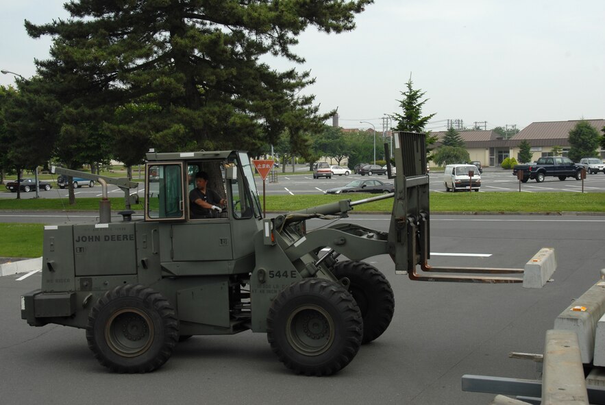 MISAWA AIR BASE, Japan -- A contractor from 35th LRS sets up barrier engagements outside the base exchange July 7, 2008.  The barriers were placed to test a portion of Misawa'a barrier plan ensuring base compliance.  (U.S. Air Force photo by Senior Airman Laura McFarlane)