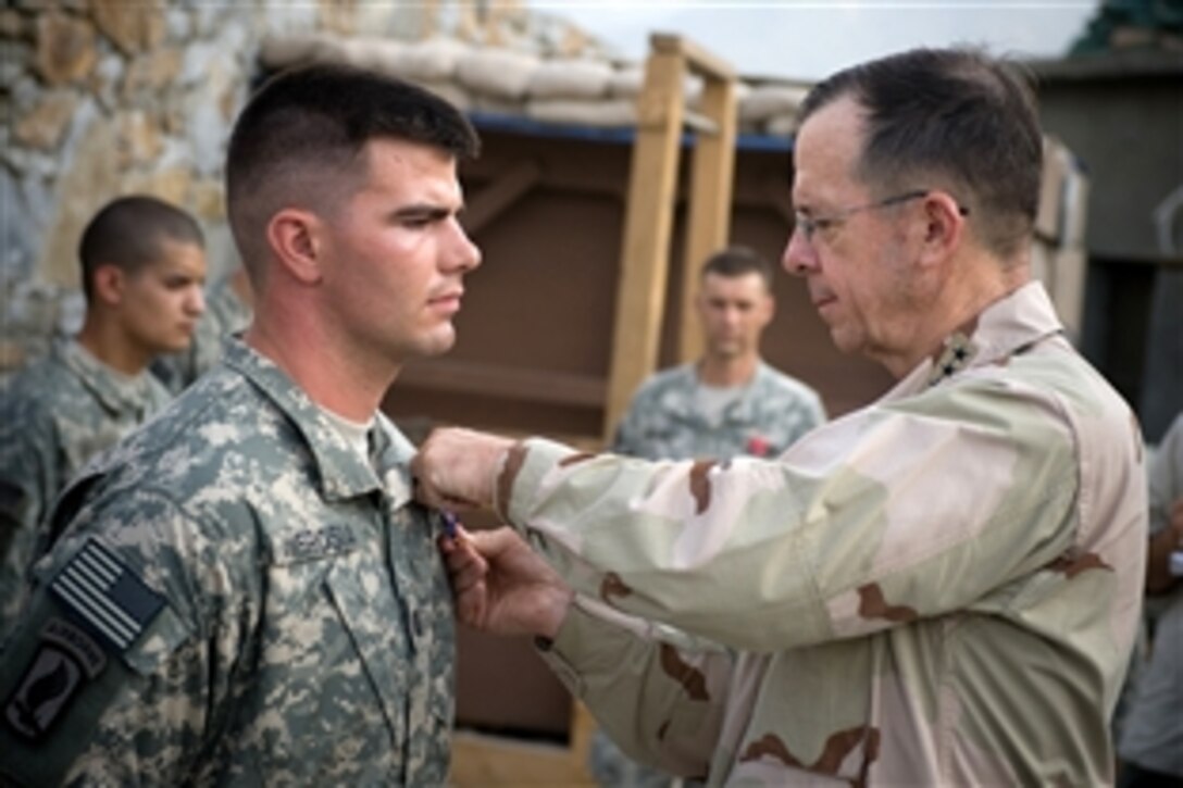 U.S. Navy Adm. Mike Mullen, chairman of the Joint Chiefs of Staff, awards the Silver Star to U.S. Army Capt. Gregory Ambrosia, Korengal Outpost, Afghanistan, July 11, 2008. Ambrosia was recognized for valor under fire after running into a hail of enemy gunfire to help save fallen comrades in September 2007. Mullen is on a six-day tour of the region to visit troops. He is also  hosting a USO contingent including NFL stars.