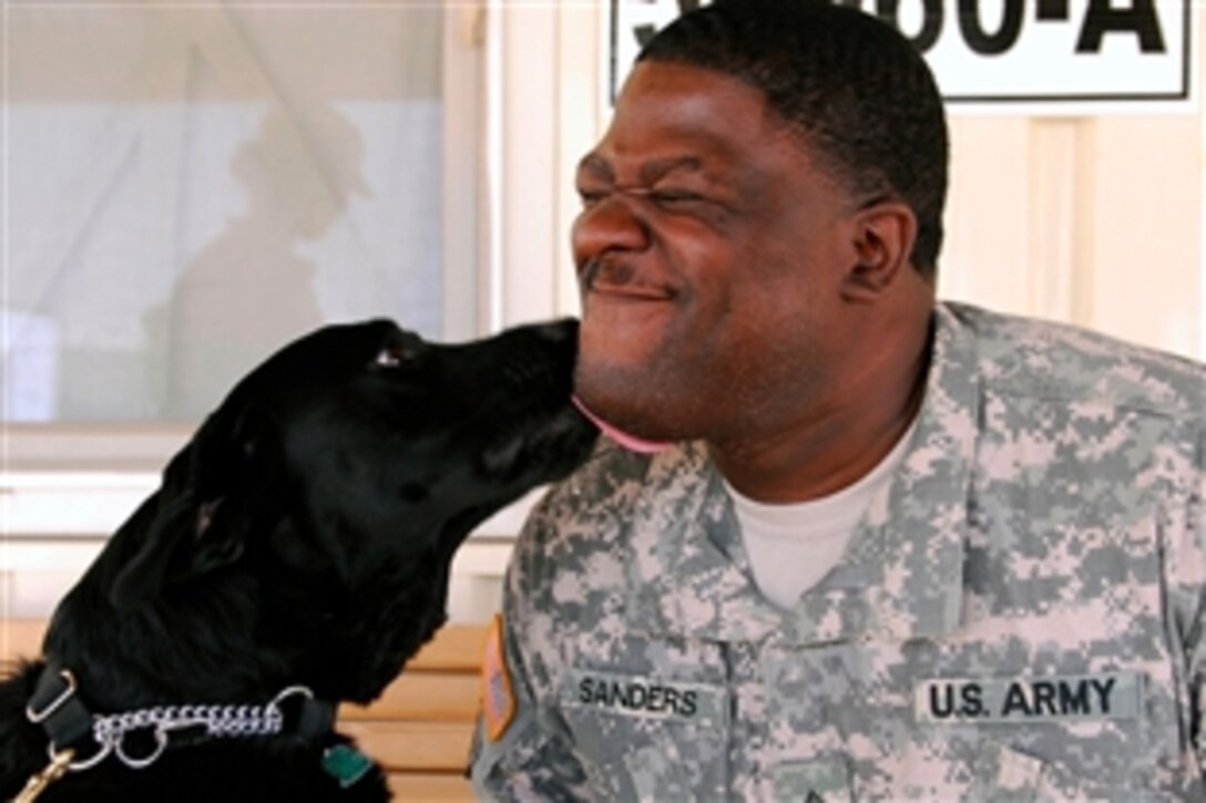 Budge a three-year-old therapy dog kisses his handler Sgt. Duane Sanders before they head out on his daily walk to visit troops in Mosul, Iraq, July 6, 2008. Sanders is an occupational therapist assigned to the 528th Medical Detachment.
