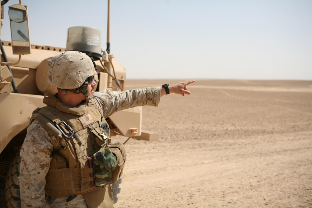 Cpl. Chris M. McQuitty, assistant platoon leader,  3rd Platoon, Company L, 3rd Battalion, 4th Marine Regiment, Regimental Combat Team 5, points out a road that insurgents could use to avoid vehicle checkpoints near Hit, Iraq, July 11. Marines with Company L performed a reconnaissance patrol through the outskirts of Hit in search of  routes the enemy could use to smuggle contraband into Hit.  The information gathered during the patrol will help the company make the area around Hit safer for Coalition forces and the Iraqis that live there.