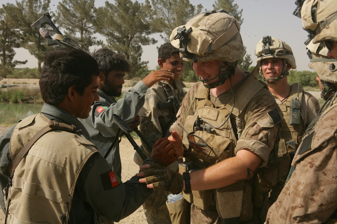 Marines with Charlie Company, 1st Battalion, 6th Marine Regiment, 24th MEU, teach Afghani National Police how to "shake and bake" after a patrol through Garmsir.  Marines have begun patrolling with Afghan National forces and British troops to began facilitating the transfer of peace keeping in Garmsir district.