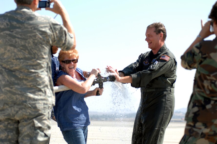 HAVING A BLAST: Colonel James A. Bouska, director of operations, Fourth Air Force gets hosed down by March Air Reserve Base Fire Department and family members. Colonel Bouska flew his last flight in preparation for his retirement ceremony July 3, at March.  (U.S. Air Force photo by Staff Sgt. Mary D. Jones)