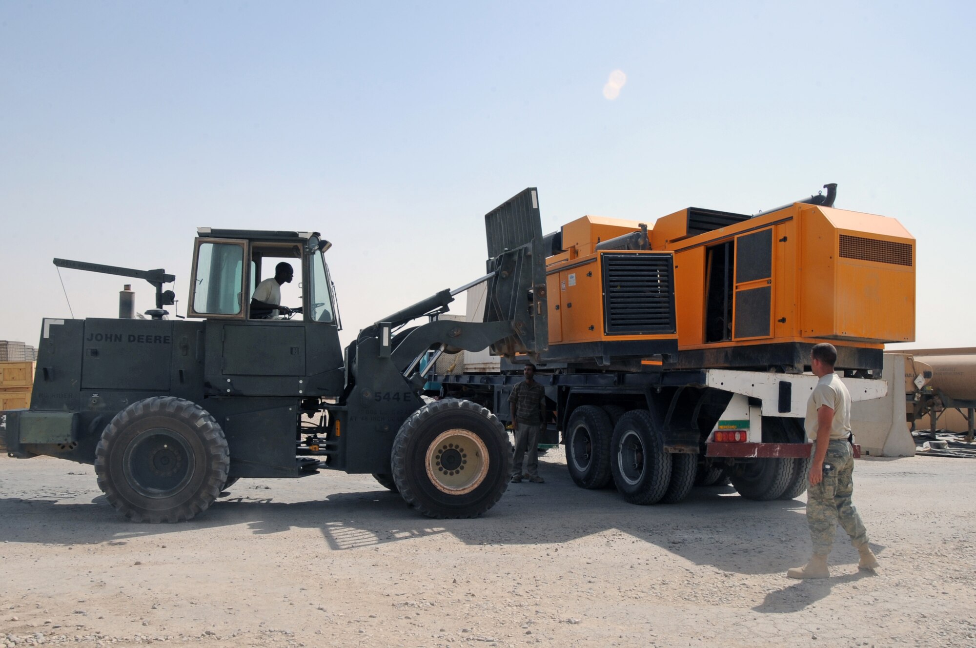 ALI BASE, Iraq -- Staff Sgts. Steven Cox and Christopher Depasquale, 407th Expeditionary Civil Engineer Squadron electrical power production technicians, load unserviceable generators onto a tractor trailer here July 12. The Air Force donated the generators to Future Services to be refurbished and reused around the base. Sergeant Cox is deployed from Andersen Air Force Base, Guam and Sergeant Depasquale is deployed from Malmstrom Air Force Base, Mont. (U.S. Air Force photo/Tech. Sgt. Sabrina Johnson)