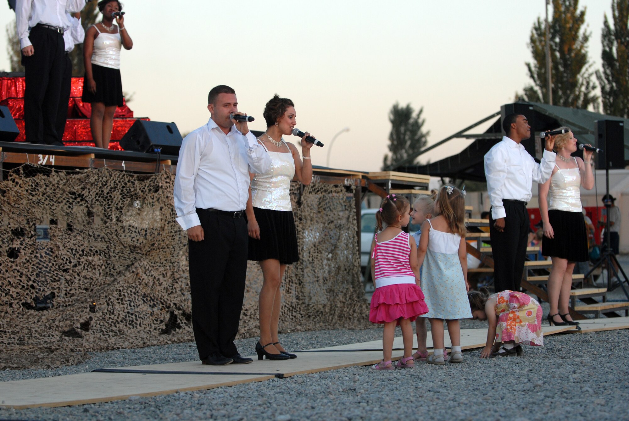 MANAS AIR BASE, Kyrgyz Republic -- Tops in Blue members perform for the Manas Air Base contractor and family appreciation day, July 11, at Manas AB, Kyrgyz Republic. Roughly 600 local Kyrgyz and hundreds of Airmen attended the activities, which included face painting, a dunk tank and barbeque. The evening's events concluded with a concert by Tops in Blue, the Air Force's premier entertainment show. (U.S. Air Force photo / Airman 1st Class Ruth Holcomb)