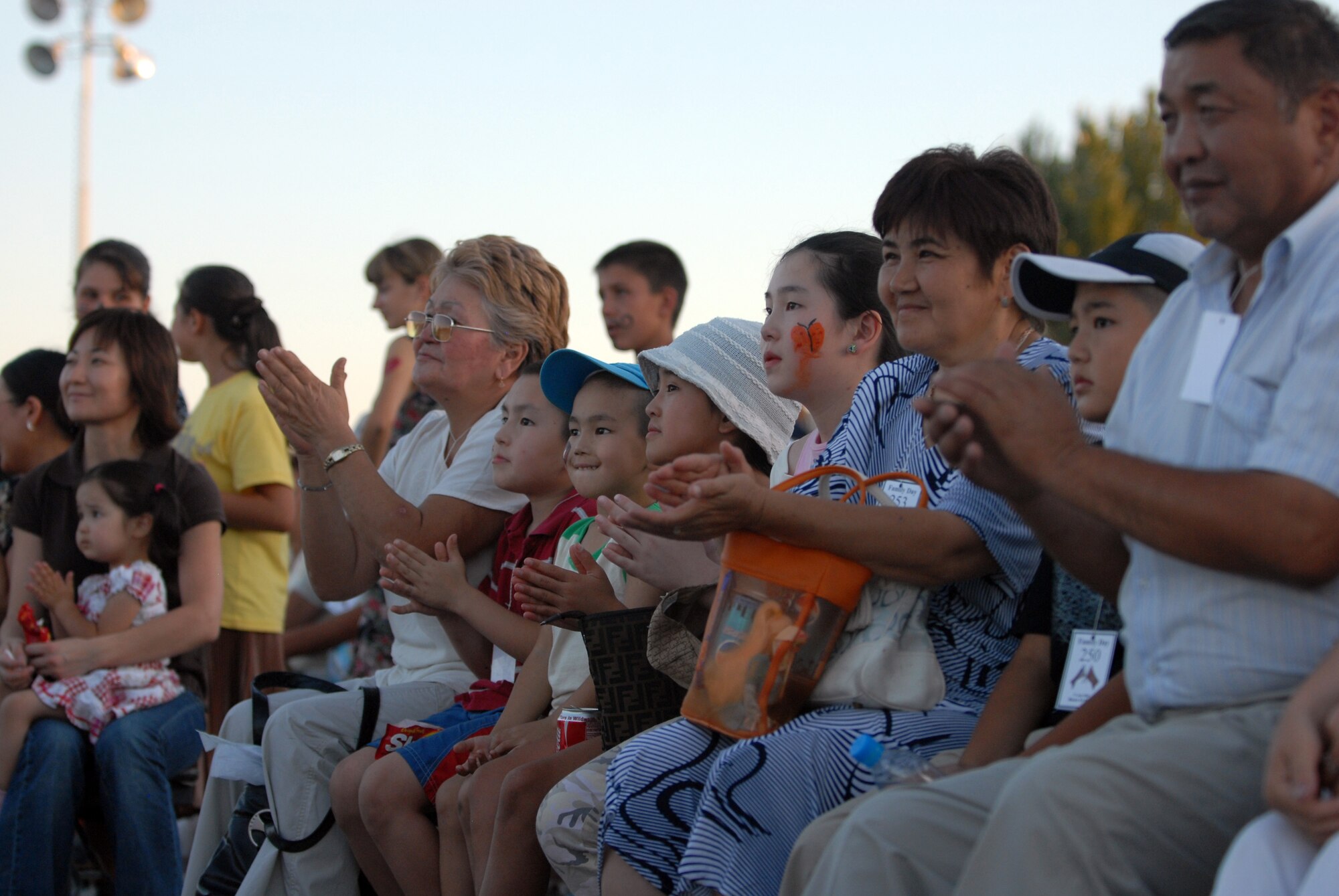 MANAS AIR BASE, Kyrgyz Republic -- Local Kyrgyz enjoy the entertainment during the Manas Air Base contractor and family appreciation day, July 11, at Manas AB, Kyrgyz Republic. Roughly 600 local Kyrgyz and hundreds of Airmen attended the activities, which included face painting, a dunk tank and barbeque. The evening's events concluded with a concert by Tops in Blue, the Air Force's premier entertainment show. (U.S. Air Force photo / Airman 1st Class Ruth Holcomb)