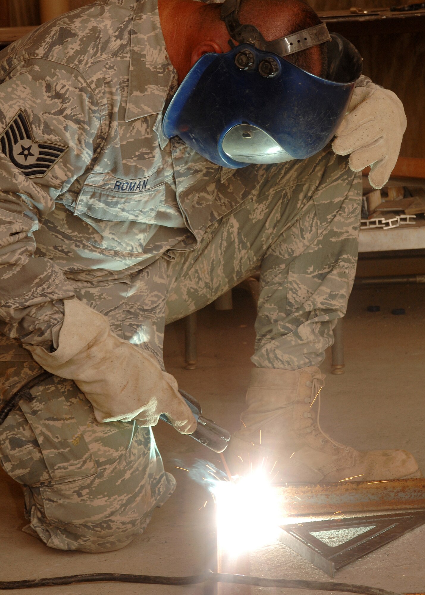 SOUTHWEST ASIA -- Sparks fly as Tech. Sgt. Anthony Roman, deployed to the 386th Civil Engineer Squadron, uses an arc welder to join a frame together on July 11 at a base in Southwest Asia. The Civil Engineer Squadron is completing a project to increase the square footage of the K-9 kennels for the 386th Expeditionary Security Forces Squadron. The metal frames will be used to build new ramps for the dogs. Sergeant Roman is deployed from the 156th Airlift Wing, Muniz Air National Guard Base, Puerto Rico. (U.S. Air Force photo/Tech. Sgt. Raheem Moore)