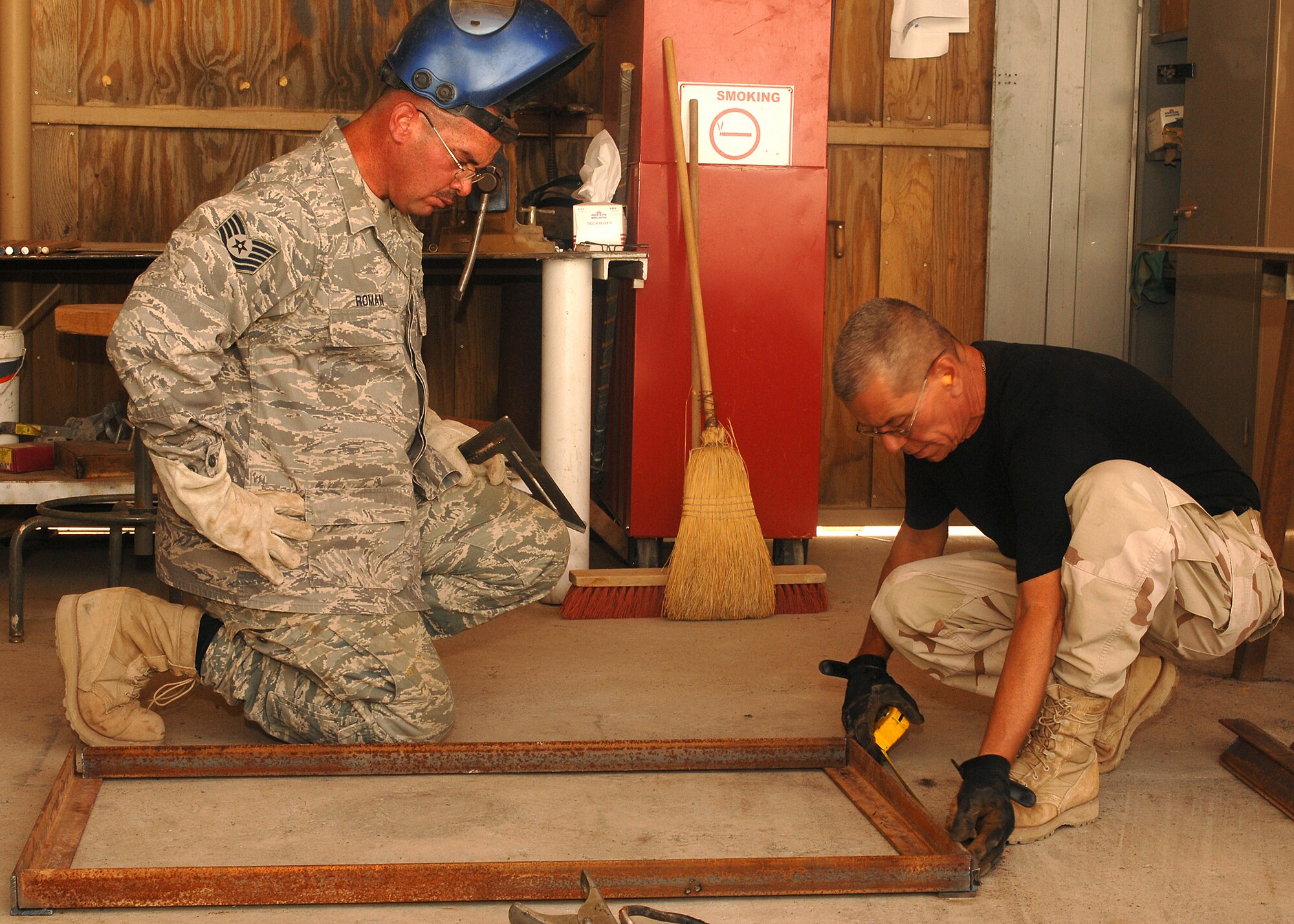 SOUTHWEST ASIA -- Master Sgt. Victor Collazo, right, and Tech. Sgt. Anthony Roman align and measure pieces of metal before they are welded together on July 11 at a base in Southwest Asia. The 386th Expeditionary Civil Engineer Squadron is completing a project to increase the square footage of the K-9 kennels for the 386th Expeditionary Security Forces Squadron. The metal frames will be used to build new ramps for the dogs. Sergeant Collazo and Sergeant Roman are deployed from the 156th Airlift Wing, Muniz Air National Guard Base, Puerto Rico. (U.S. Air Force photo/Tech. Sgt. Raheem Moore)