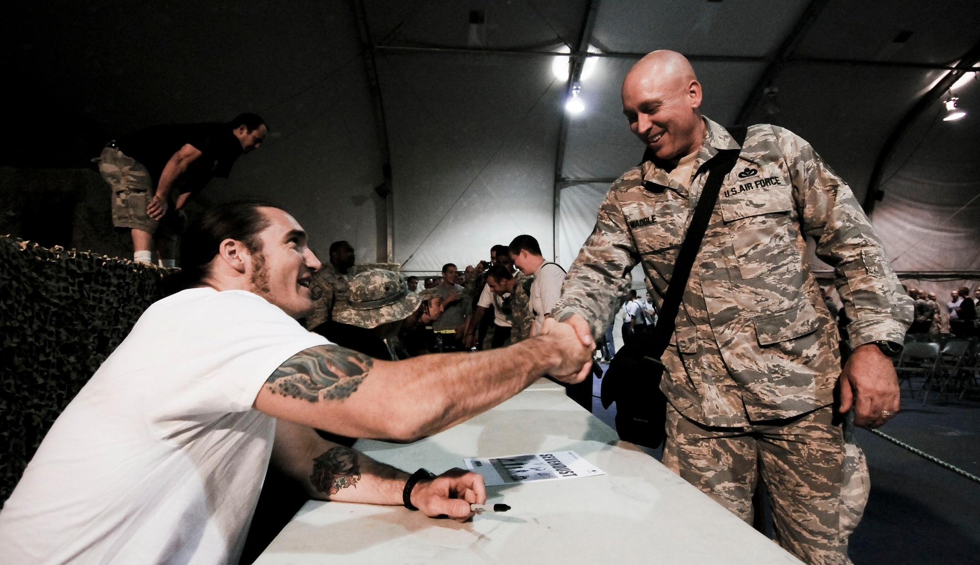BAGRAM AIR FIELD, Afghanistan -- Guitarist Clint Lowery, from rock band "Sevendust," shakes hands with Master Sgt. William Waddle, from San Antonio, Texas, after a performance here on July 12, 2008. "Sevendust," from Atlanta, Ga., gave a USO-sponsored tour throughout Southwest Asia, performing for deployed coalition forces. Sergeant Waddle is deployed as the first sergeant for the utilities detatchment of the 155th Expeditionary Civil Engineer Squadron. (U.S. Air Force photo by Staff Sgt. Samuel Morse)