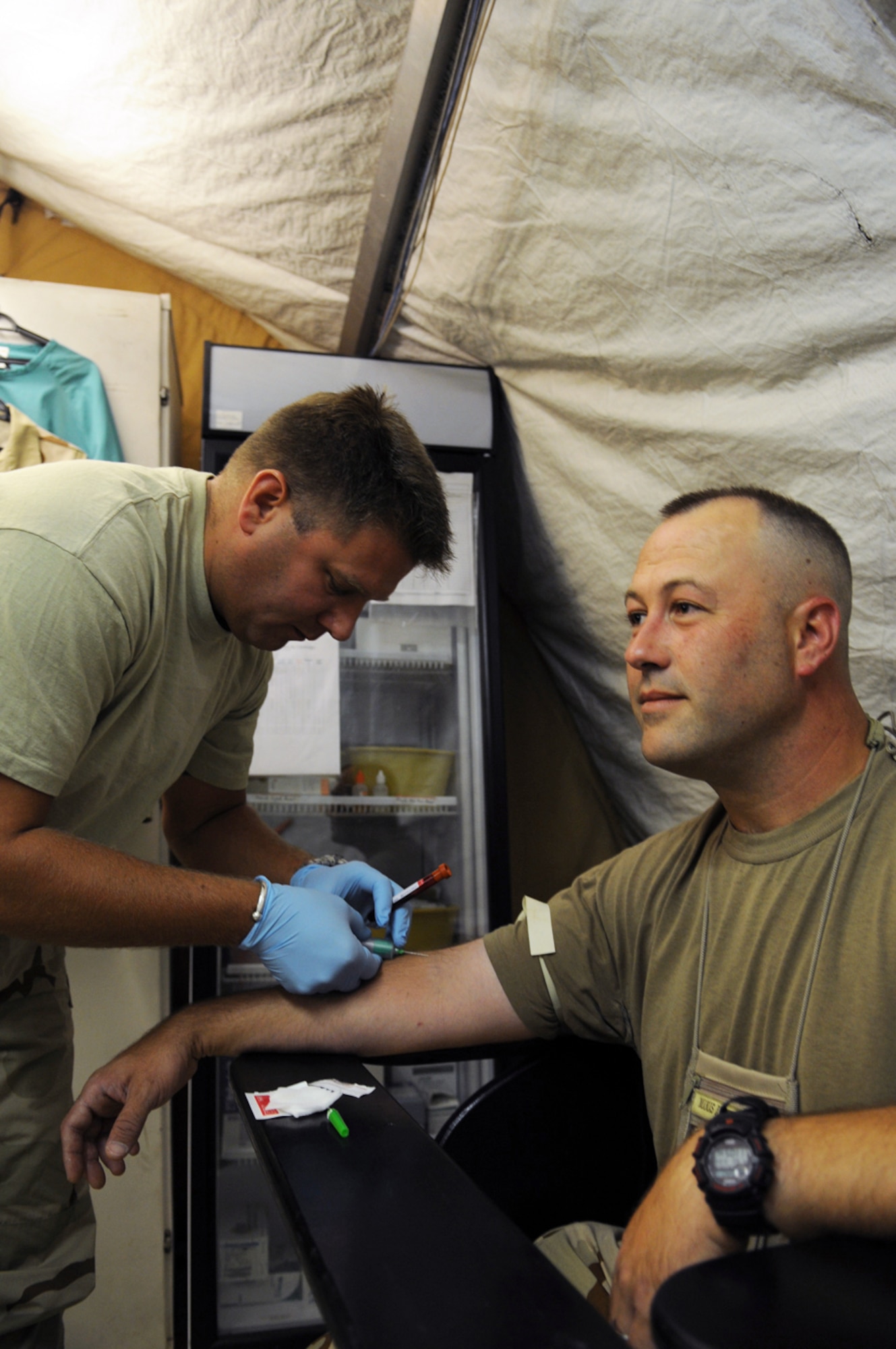 MANAS AIR BASE, Kyrgyz Republic - Master Sgt. Michael Clough, the independent duty medical technician from the 376th Expeditionary Medical Group, draws a blood sample from Master Sgt. Britian Yucum, 376th Expeditionary Medical Group, July 10. Sergeant Clough is deployed here from the Utah Air National Guard's 191st Air Refueling Squadron, based out of Salt Lake City International Airport. (U.S. Air Force photo / Airman 1st Class Ruth Holcomb) The message is ready to be sent with the following file or link attachments: