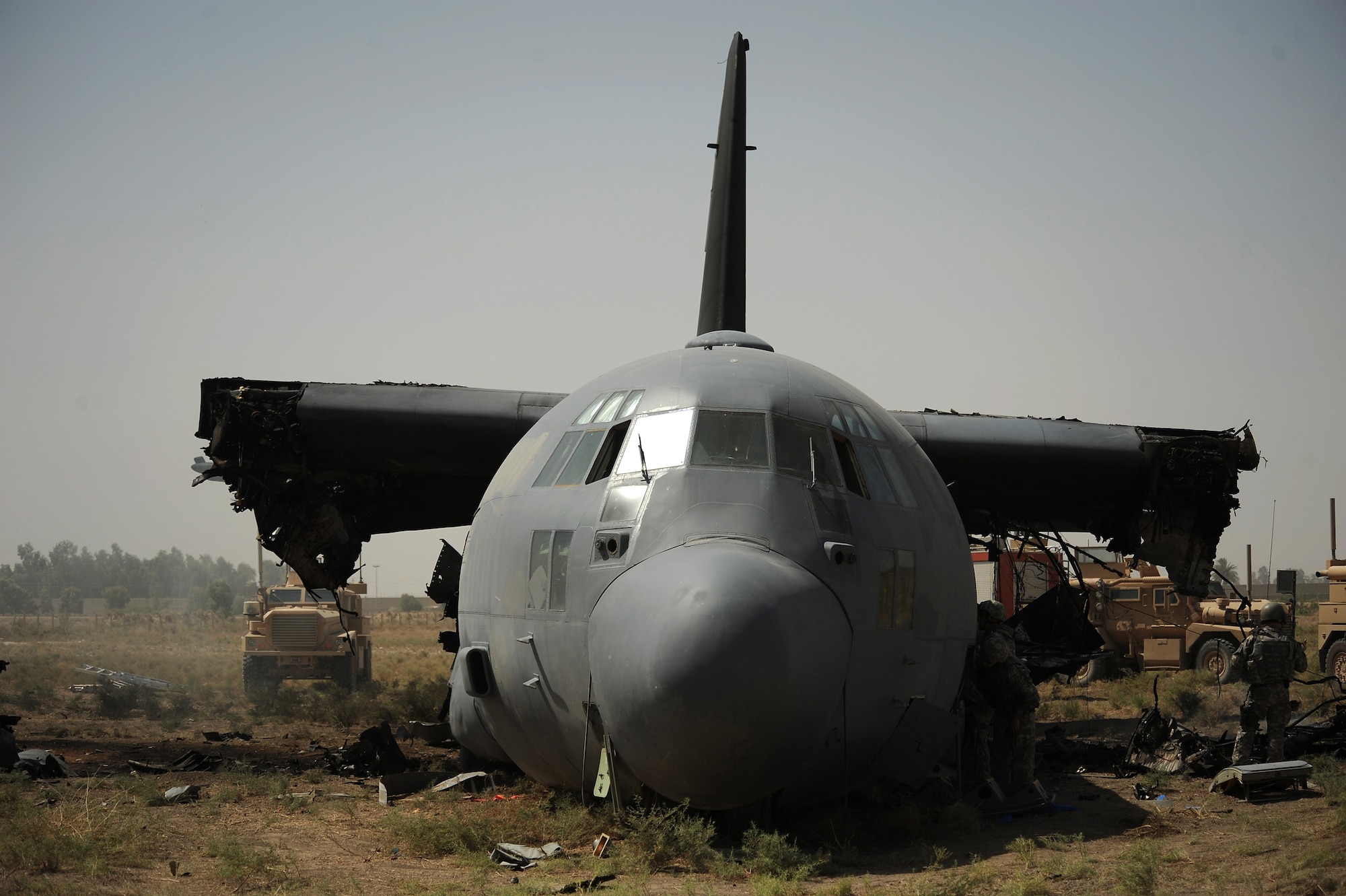 Members of the 447th Air Expeditionary Group inspect a C-130 Hercules after controlled detonations were used to separate the wings from the body on July 7, 2008. An Explosive Ordinance disposal team is using a series of controlled detonations designed to divide the airplane into smaller pieces so it can be moved.  The C-130 made an emergency landing in a field north of the Baghdad International Airport shortly after take-off on June 27.  U.S. Air Force photo/Tech. Sgt. Jeffrey Allen