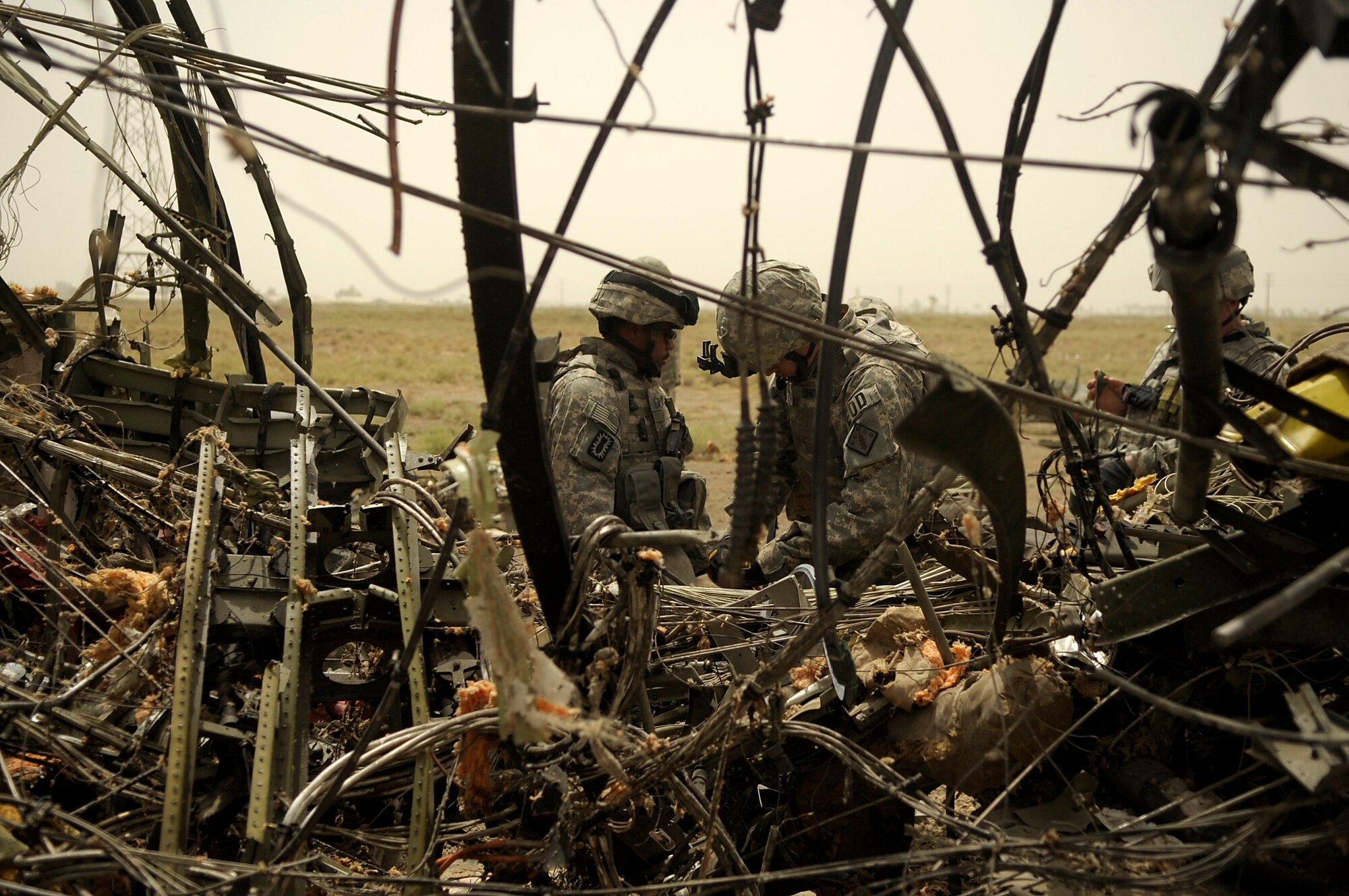Explosive Ordinance Disposal personnel from the 447th Air Expeditionary Group at Sather Air Base, Iraq survey their work after using explosives to dismantle a C-130 Hercules on July 7, 2008. The EOD team is using a series of controlled detonations designed to divide the airplane into smaller pieces so it can be easily moved.  The C-130 made an emergency landing in a field north of the Baghdad International Airport shortly after take-off on June 27.  U.S. Air Force photo/Tech. Sgt. Jeffrey Allen