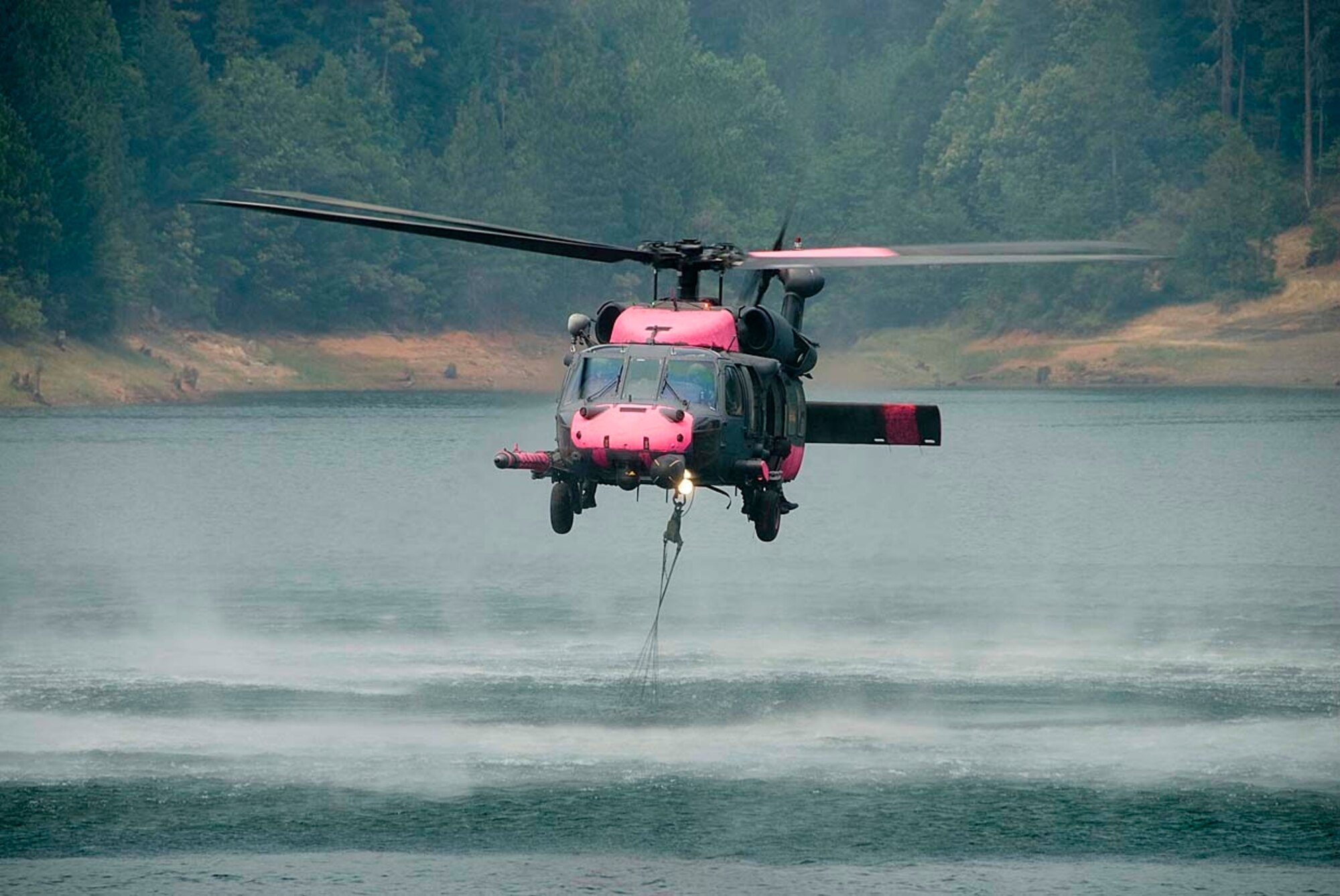 Jolly 92, an HH-60G Pave Hawk from the 129th Rescue Wing, a California Air National Guard unit based out of Moffett Federal Airfield near Mountain View, Calif., performs multiple water bucket missions over Butte County wildfires in California. The wing is the only unit in the Air Force qualified to participate in water bucket drops. There are currently 21 rotary-wing aircraft supporting the California wild fires, nine aircraft from other states. (U.S. Air Force photo by Staff Sgt. Andrew Hughan) 
