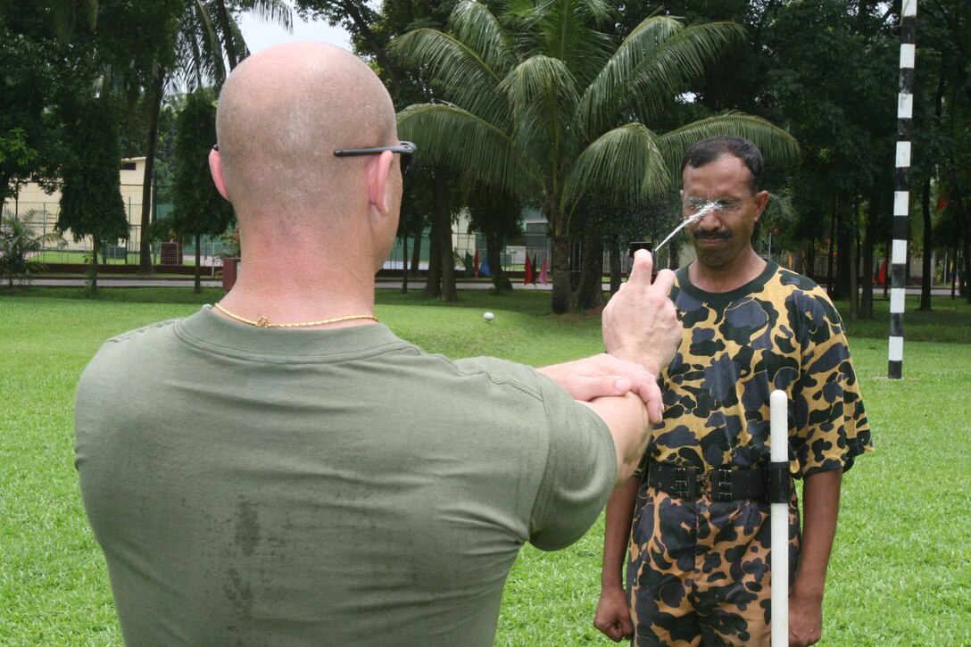 Gunnery Sgt. Dennis Dodd douses a Bangladesh Rifles soldier with oleoresin capsicum (pepper) spray July 14 during Non-Lethal Weapons Executive Seminar 2008 here. The training is designed to understand the effects of pepper spray before deciding to employ it. Dodd is the senior anti-terrorism force protection instructor with III Marine Expeditionary Force's Special Operations Training Group.