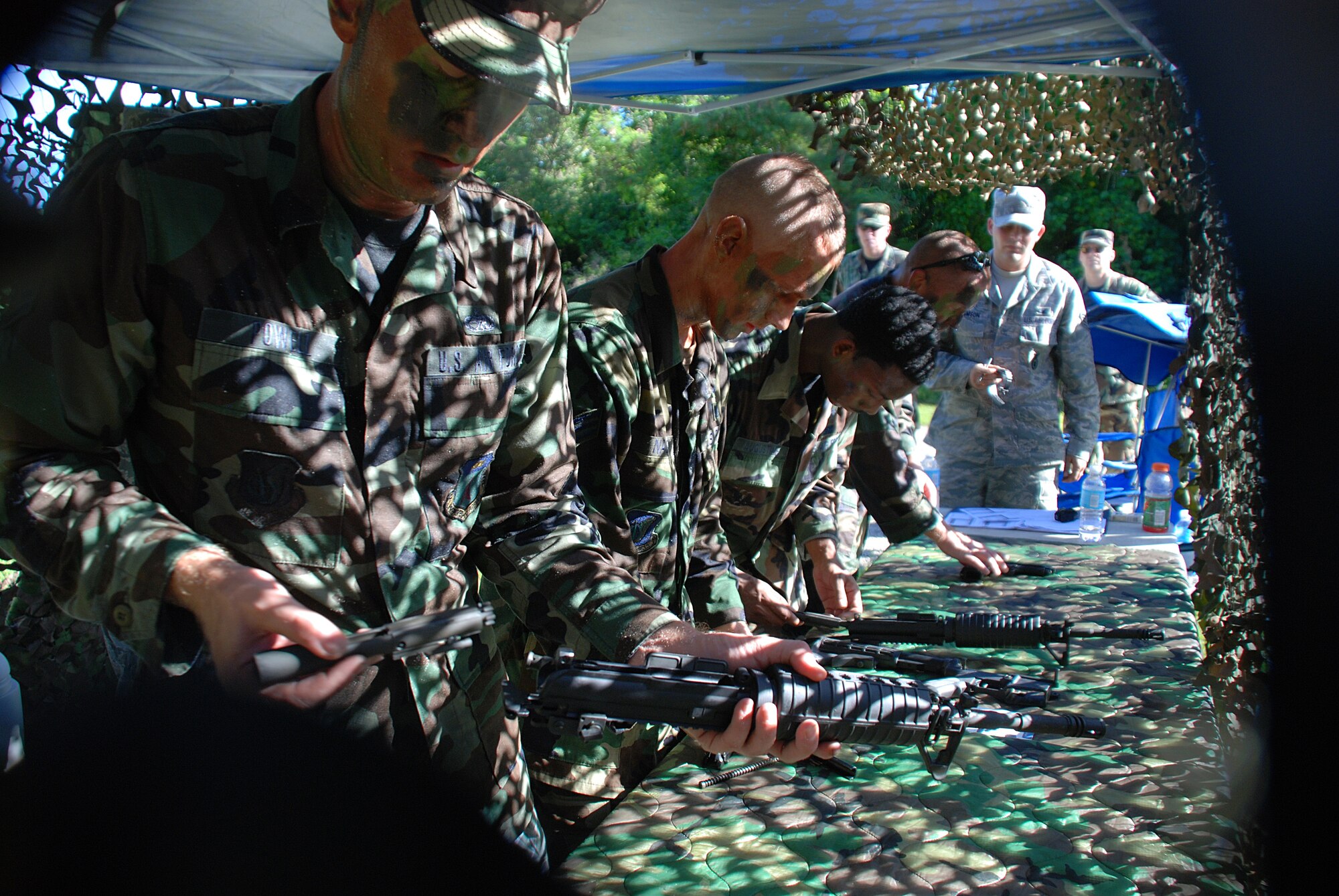 The 644th Combat Communications Squadron team, the Dragons assemble M-16s and M-9s for time during the annual Warrior Day Challenge held here July 11. This year's Warrior Day Challenge also tested Airman in the areas of basic fighting scenarios ranging from combat trauma and personal recovery, an improvised explosive device vehicle inspection, hostile force apprehensions, a MCU-2 gas mask inspection and the event finished with an Airman's Manual test. (U.S. Air Force photo by Senior Airman Brian Quay)