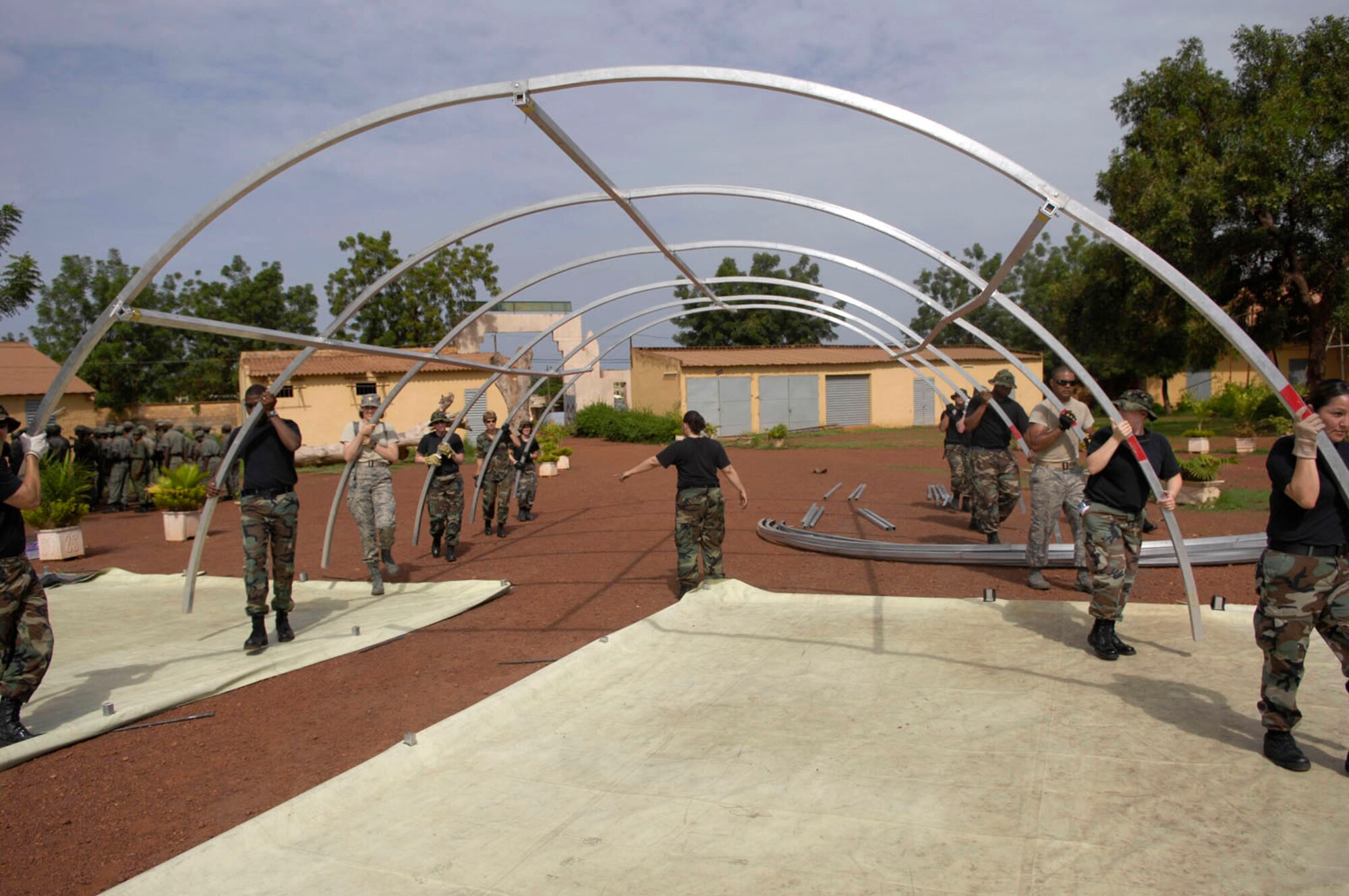 Medical personnel deployed in support of MEDFLAG 08 erect the frame for a tent while setting up an expeditionary medical support unit July 13.  More than 90 servicemembers deployed to Bamako, Mali, July 11 for MEDFLAG 08, a multinational medical training exercise designed to enhance medical capabilities and readiness for U.S. and African Forces.  (U.S. Air Force photo/Senior Airman Michael S. Dorus)
