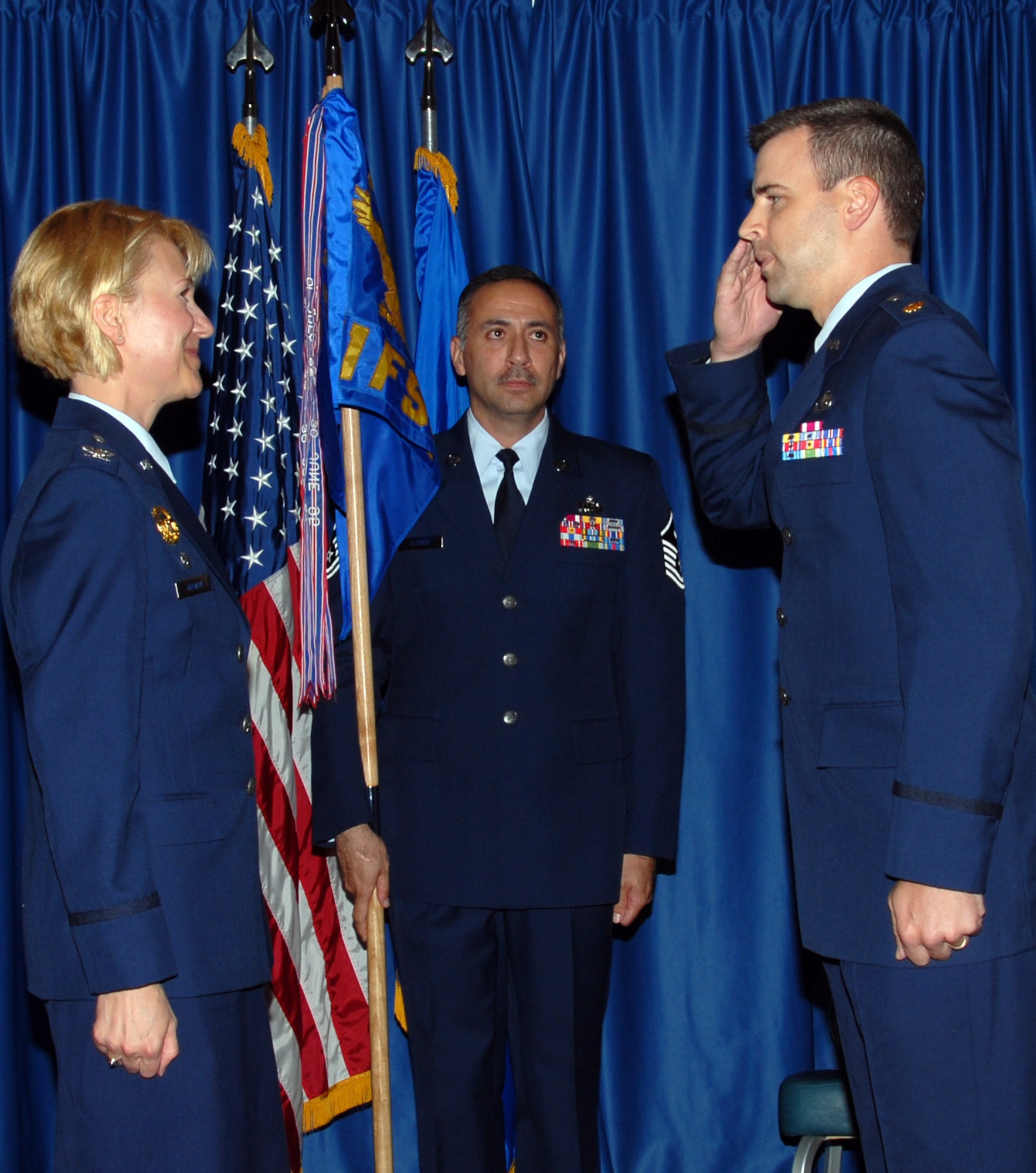 Maj. Paul Johnston salutes Col. Jennifer Graham, 71st Mission Support Group commander, after assuming command of the 71st Force Support Squadron during a ceremony July 10 at Vance AFB, Okla. Holding the 71st FSS guidon is Master Sgt. Raul Flores, the 71st MSG first sergeant. (U.S. Air Force photo by Angie Roche)

