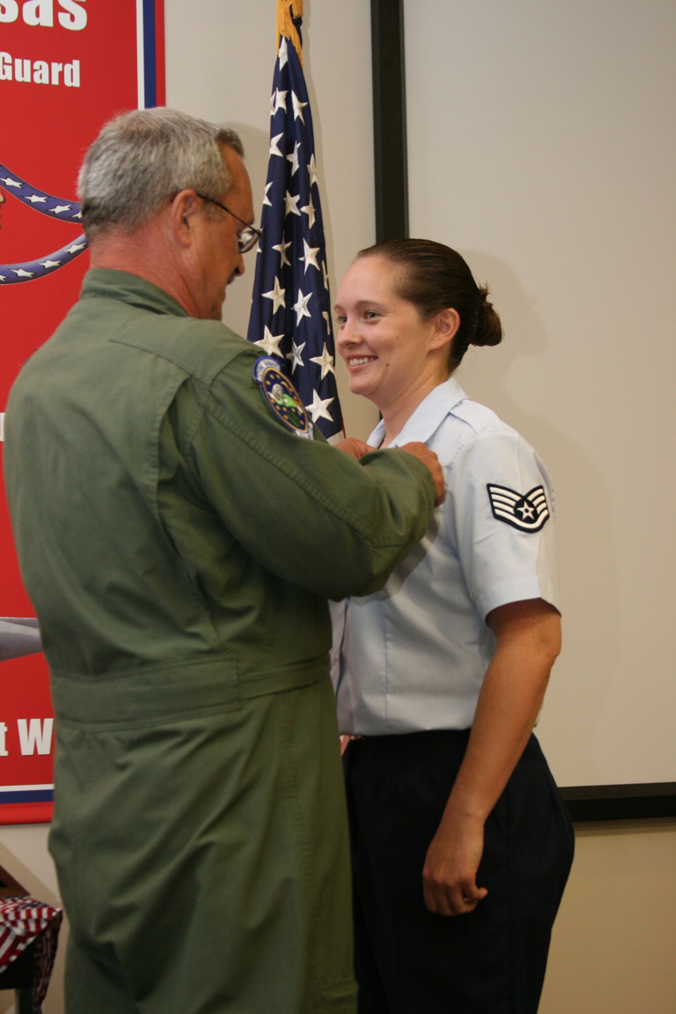 Chief Master Sgt. Jim Tavernese, chief loadmaster of the Air Force Reserve’s 95th Airlift Squadron at Pope Air Force Base, N.C., pins loadmaster wings onto Staff Sgt. Amie Starcher’s uniform. Sergeant Starcher is the last Air Force student to graduate from the Air National Guard’s Enlisted Aircrew Academic School. The school, run by the Arkansas ANG’s 189th Airlift Wing, will continue to train Marines while Air Force students will be taught at Lackland Air Force Base, Texas. (Photo by Master Sgt. Bob Oldham)