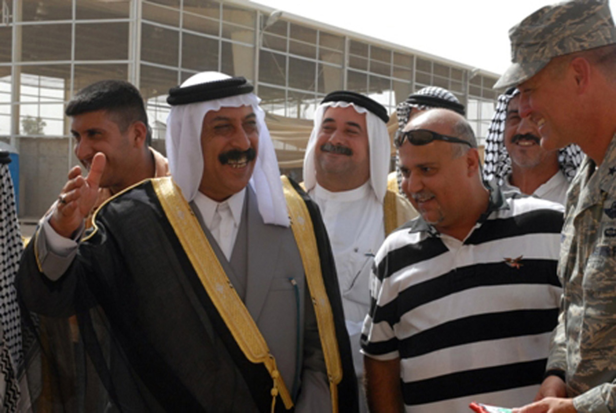 Sheikh Saad Hasan Altememy, a local leader near Balad, Iraq, confers with Air Force Brig. Gen. Brian Bishop July 11during a ribbon-cutting ceremony for an Iraqi-run recycling center at Joint Base Balad, Iraq. The recycling center will provide 30 jobs to local Iraqis and assist current efforts to sort through daily garbage collection on base for recyclables. The recyclables will then be shipped off base and sold for profit on the Iraqi market. General Bishop is the 332nd Air Expeditionary Wing commander and installation commander. (U.S. Army photo/Sgt. Robert G. Cooper III)