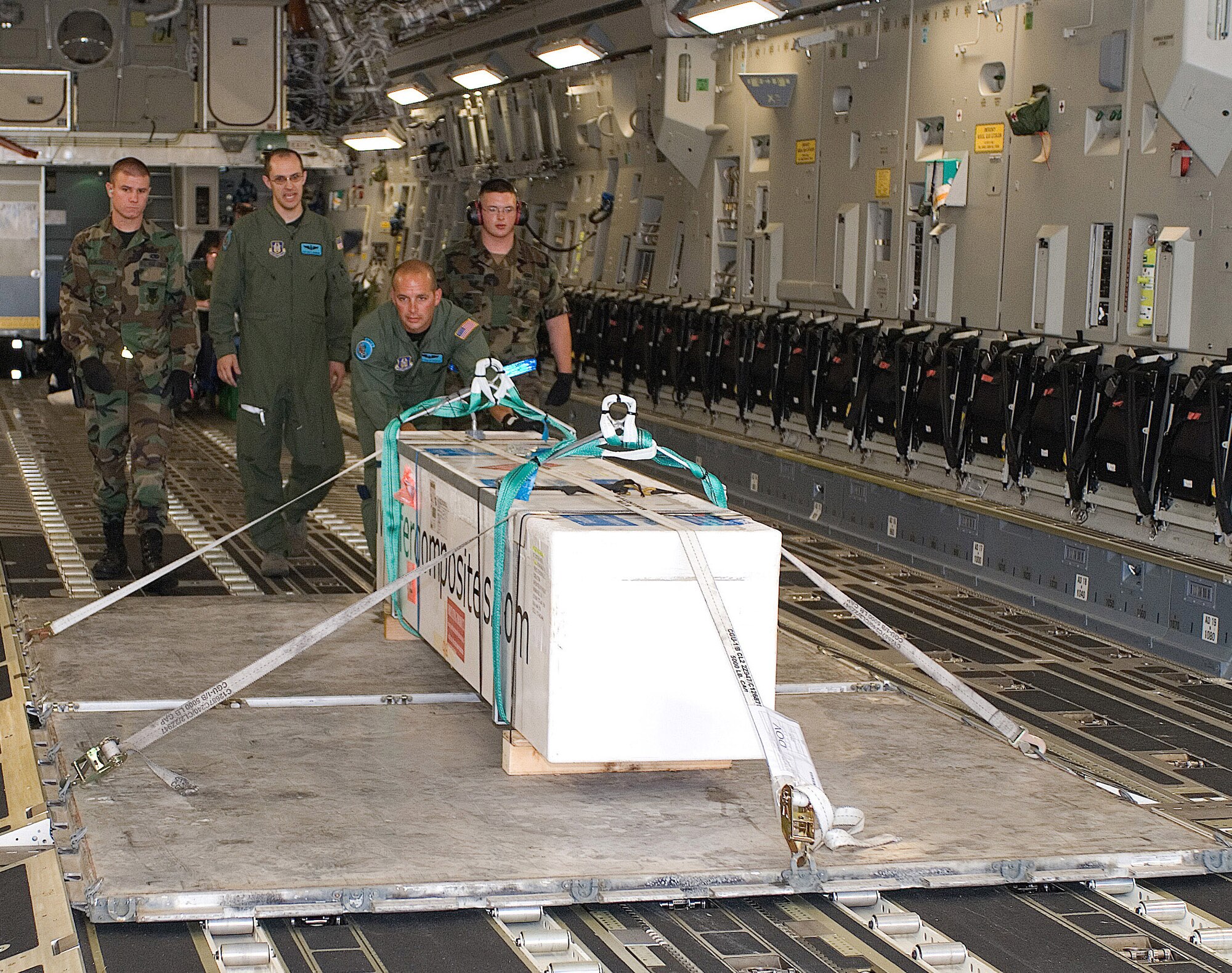 Senior Airman Michael Goicoechea, Master Sgts. Eric Weinmann and Phillip Vickery and Airman 1st Class James Manier unload a giant squid from a C-17 Globemaster III assigned to Dover Air Force Base, Del., July 11.Two giant squids were flown from Europe to Dover AFB July 11. The giant squids are headed to The Smithsonian National Museum of Natural History for display in the new Sant Ocean Hall, which opens Sept. 27 in Washington, D.C.  (U.S. Air Force photo/Roland Balik)