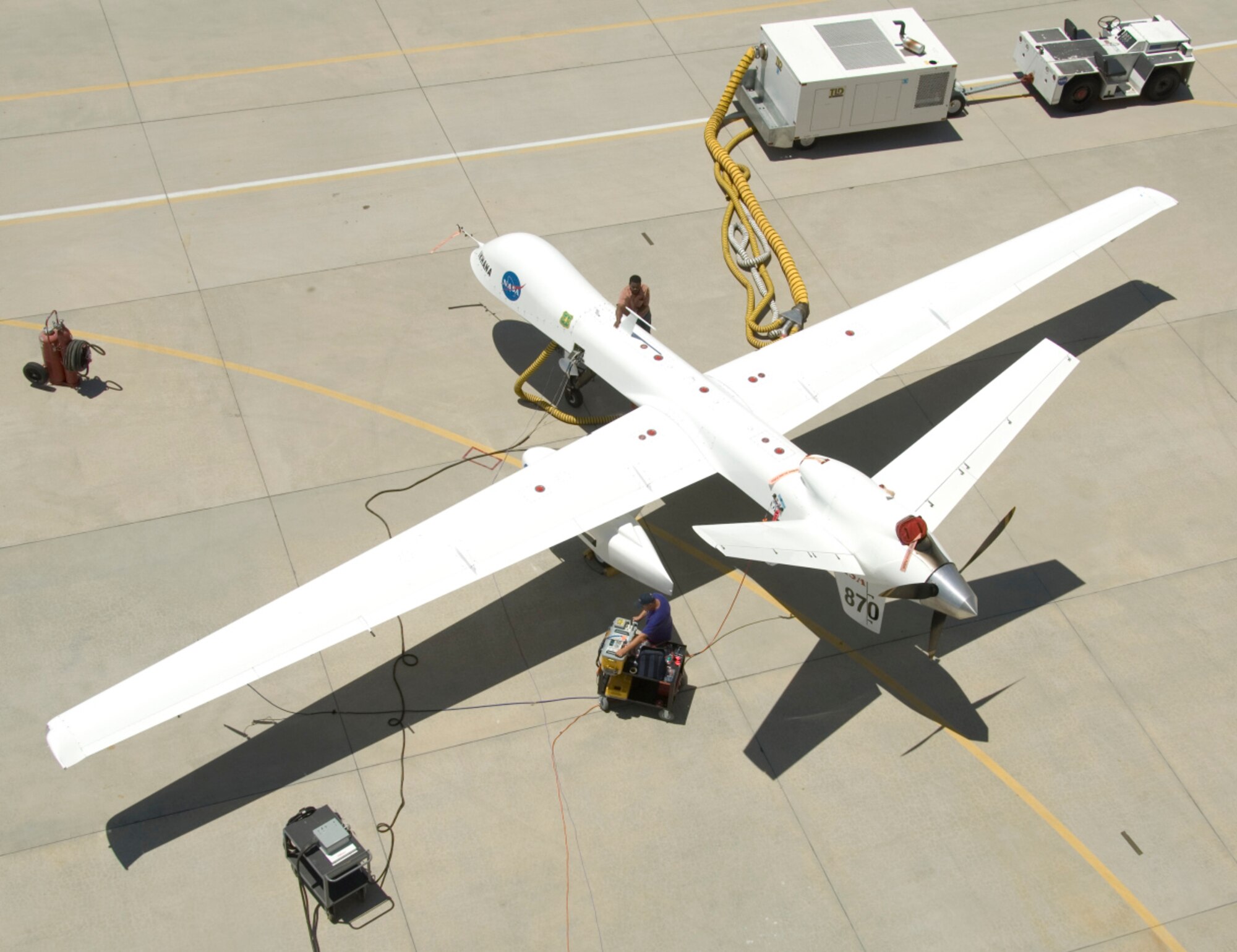 A ground crewman unplugs electrical connections during pre-flight checks of NASA's Ikhana research aircraft. Ikhana's payload pod is mounted on the left wing. Ikhana's onboard sensor can detect temperature differences from less than one-half degree to approximately 1,000 degrees Fahrenheit. The scanner operates like a digital camera with specialized filters to detect light energy at visible, infrared and thermal wavelengths. (NASA photo by Tony Landis)