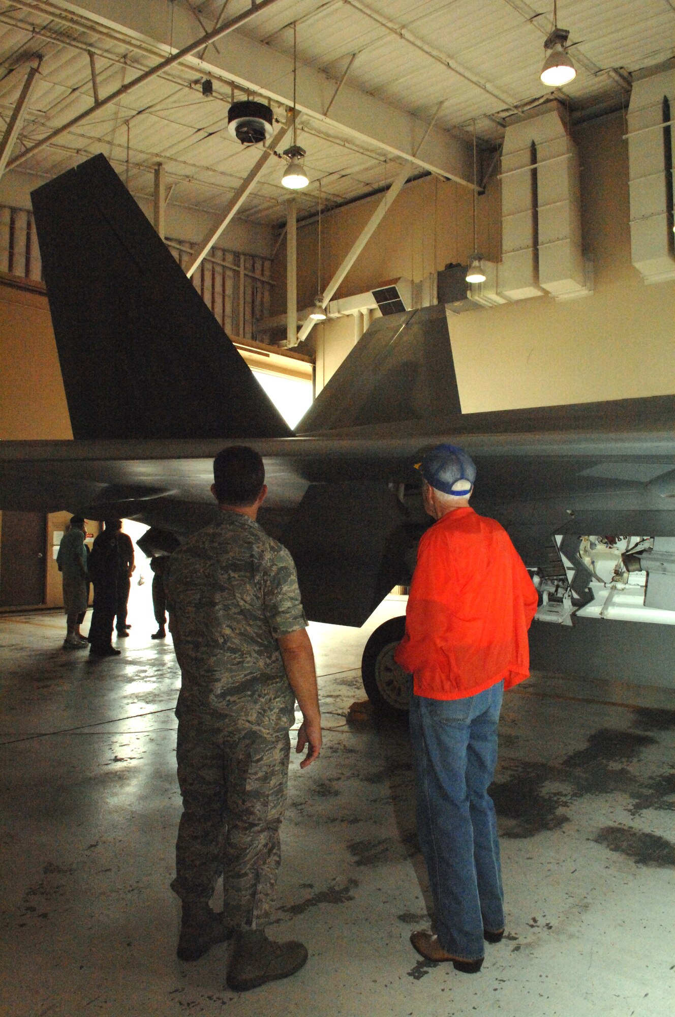 Col. George Torres, 49th Maintenance Group commander, and retired Col. William Norris, who flew 155 missions in support of the Berlin Airlift 60 years ago, look at the Holloman-tailed F-22A Raptor  at a static display near Bldg. 894 at Holloman Air Force Base, N.M., July 11. All three of the Berlin Airlift veterans that viewed the F-22 now live in New Mexico. (U.S. Air Force photo/Airman Sondra M. Wieseler)