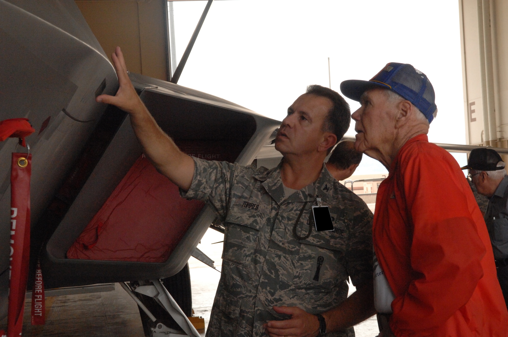 Col. George Torres, 49th Maintenance Group commander, explains characteristics of an F-22A Raptor to retired Col. William Norris, a then-C-54 pilot who flew 155 missions in the support of the Berlin Airlift. He was one of three veterans of the Berlin Airlift who viewed the F-22 static display near Bldg. 894 at Holloman Air Force Base, N.M., July 11. (U.S. Air Force photo/Airman Sondra M. Wieseler)