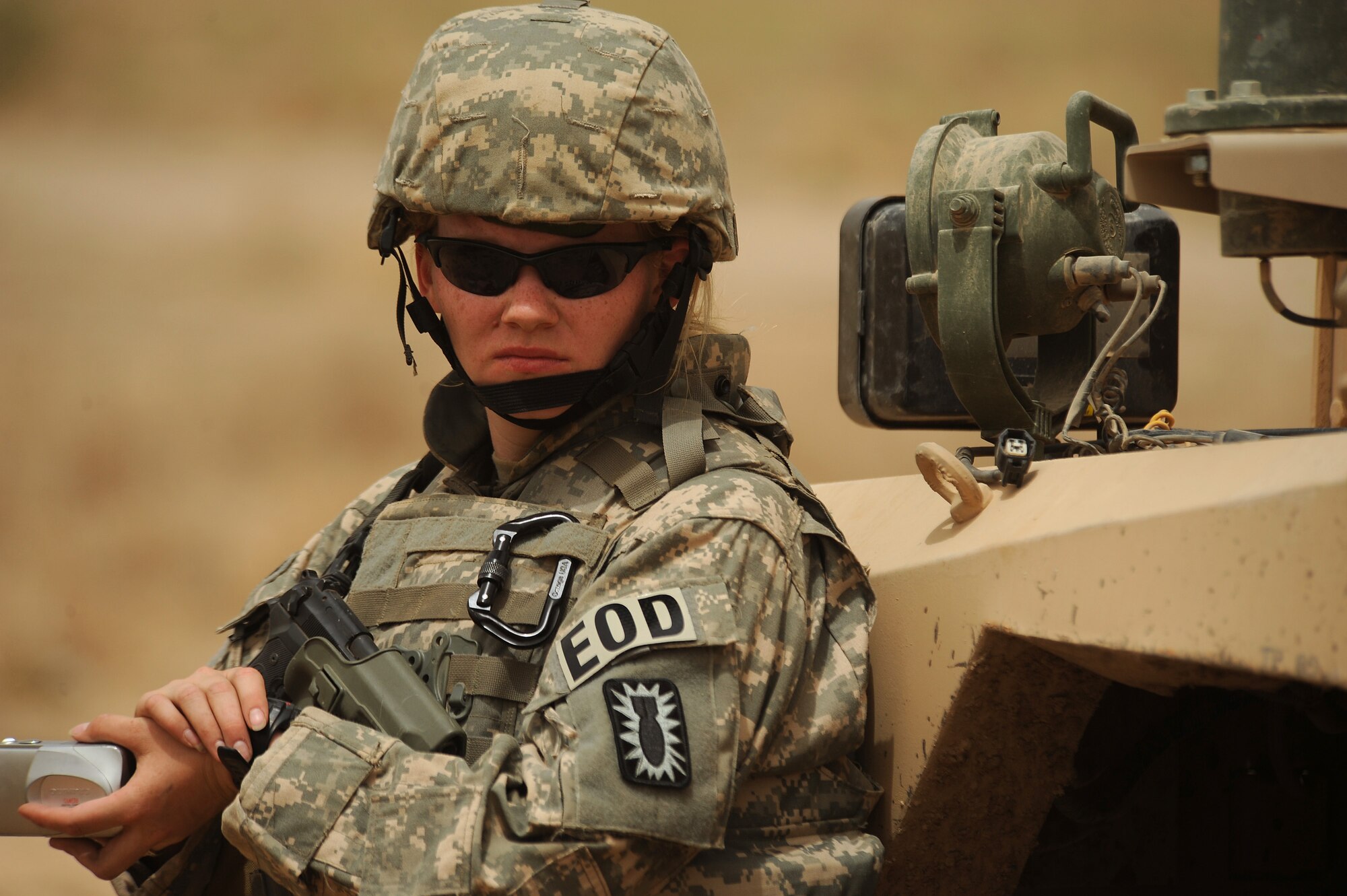 Senior Airman Kimberly Pate of the 447th Air Expeditionary Group's Explosive Ordinance Disposal team prepapres to take a picture of an explosion that will separate the front section of a C-130 Hercules from the rest of the plane on July 7, 2008. The EOD team is using a series of controlled detonations designed to divide the airplane into smaller pieces so it can be moved.  The C-130 made an emergency landing in a field north of the Baghdad International Airport shortly after take-off on June 27.  U.S. Air Force photo/Tech. Sgt. Jeffrey Allen