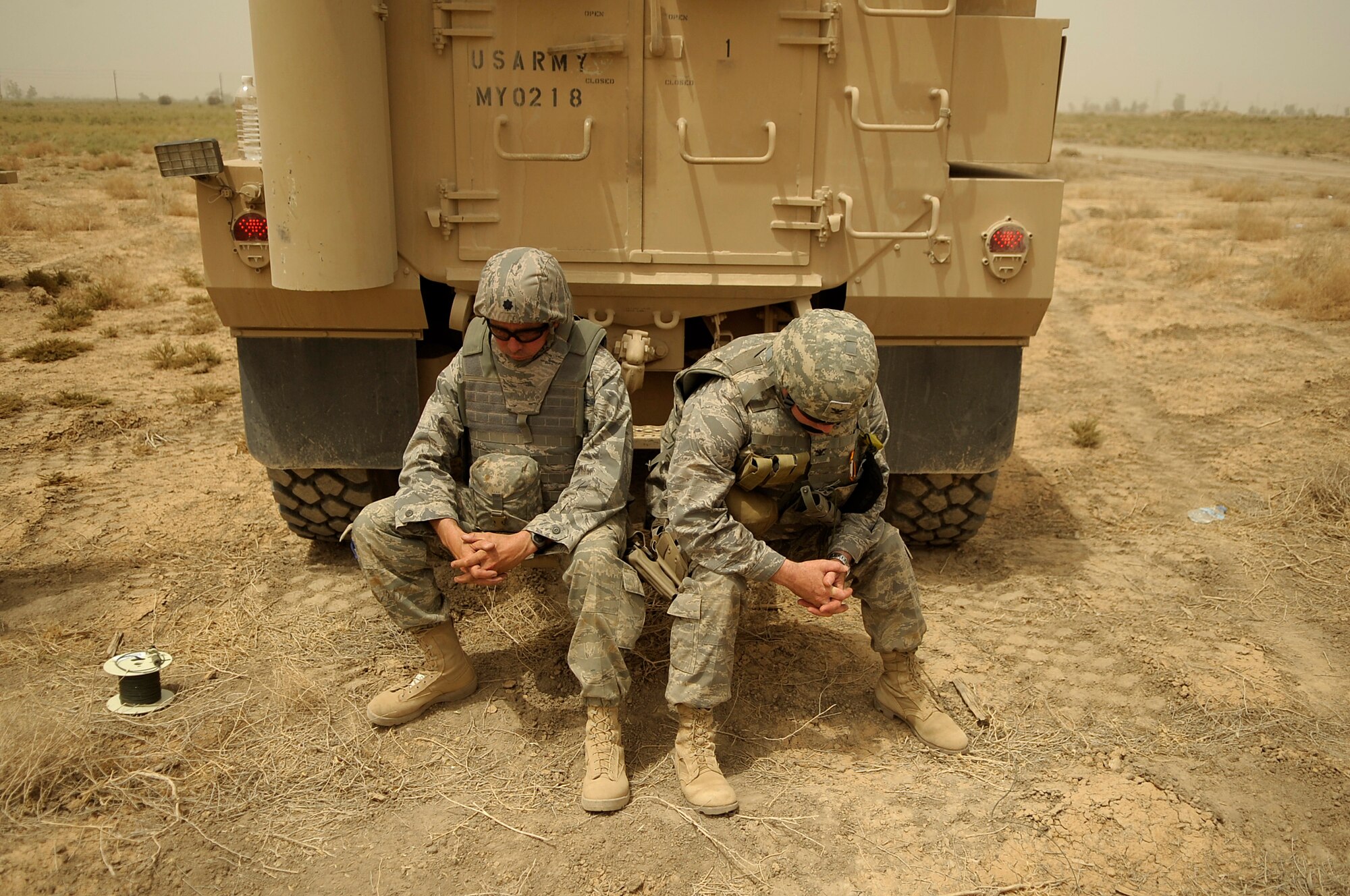 Lt. Col. Robert Brisson (left), 447th Expeditionary Operations Support Squadron commander and Col. David Pavey, 44th Air Expeditionary Group commander take a moment to rest during an operation to dismantle a C-130 Hercules   using a series of controlled detonations  on July 7, 2008. An Explosive Ordinance Disposal team is using a series of controlled detonations designed to divide the airplane into smaller pieces so it can be moved.  The C-130 made an emergency landing in a field north of the Baghdad International Airport shortly after take-off on June 27.  U.S. Air Force photo/Tech. Sgt. Jeffrey Allen