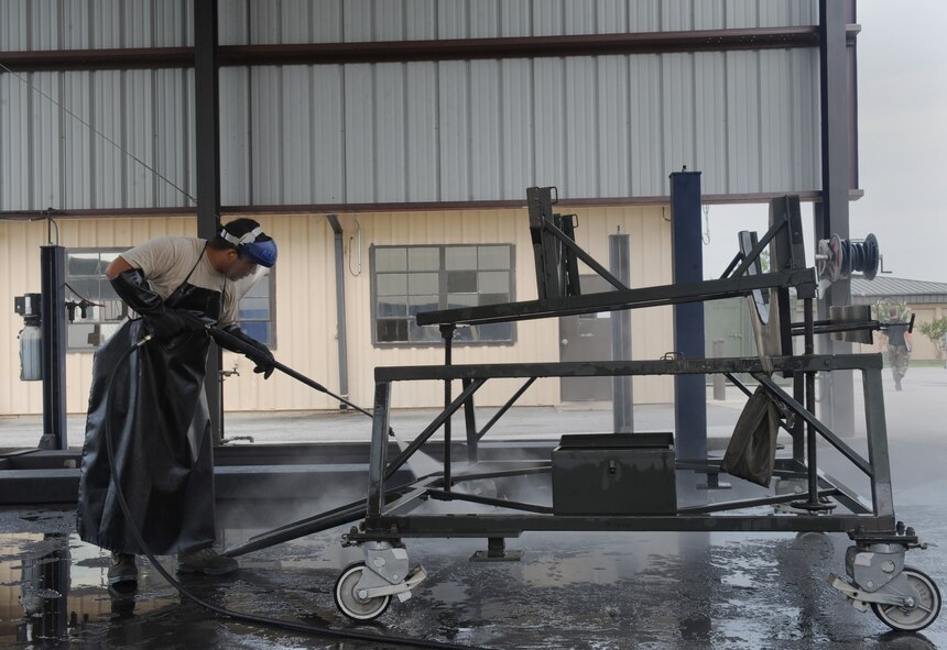 MOODY AIR FORCE BASE, Ga. -- Senior Airman Reys Cruz, 23rd Equipment Maintenance Squadron aerospace ground equipment journeyman, cleans a radome dolly here July 14. The dolly is used as a stand for an HC-130P King nose cone. (U.S .Air Force photo by Senior Airman Gina Chiaverotti)