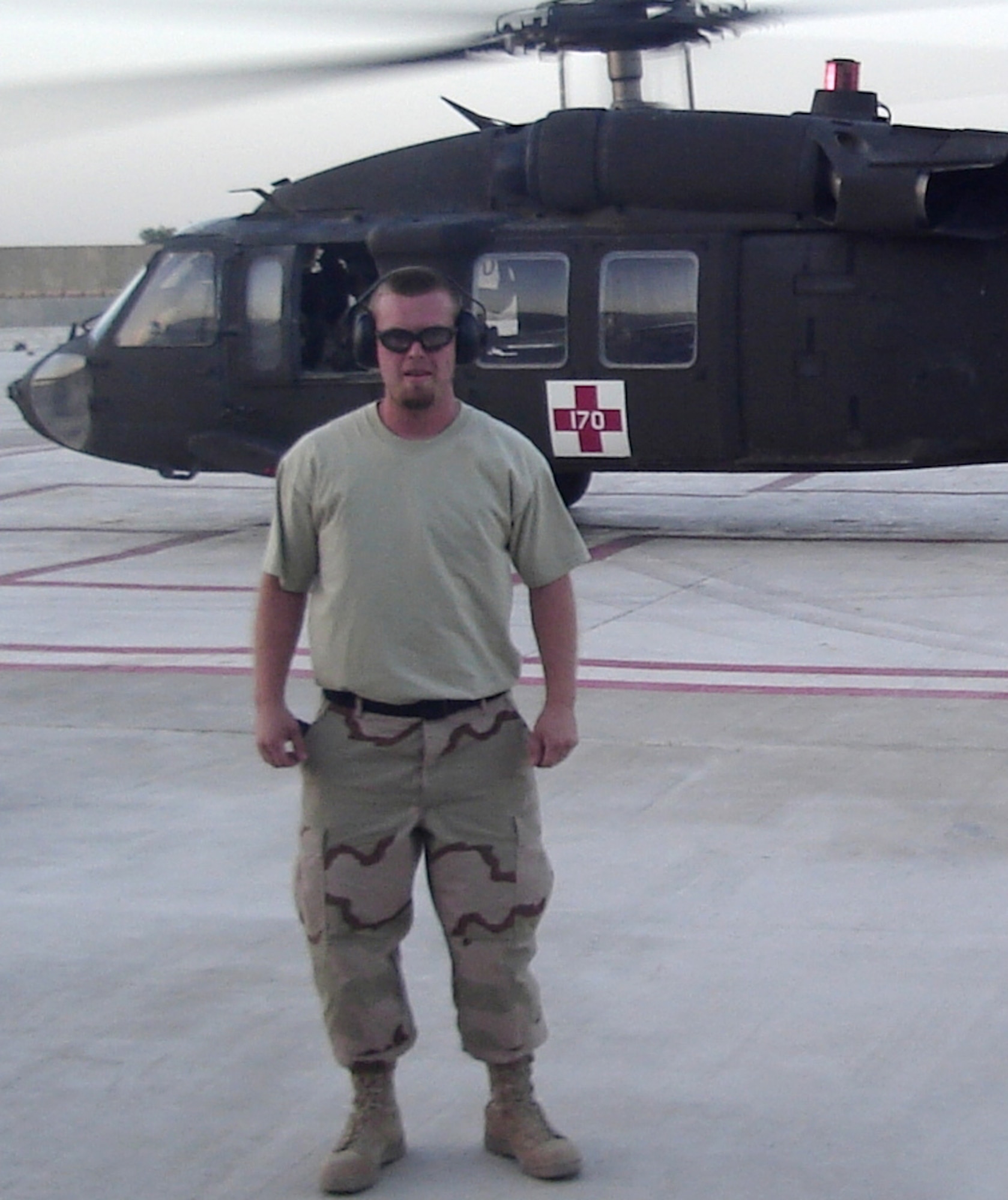 DRMS worker Curtis Mitchell stands on a helicopter pad at Camp Anaconda, Balad Iraq.  He volunteers at the base hospital to remove patients from medical helicopters and take them to the hospital.