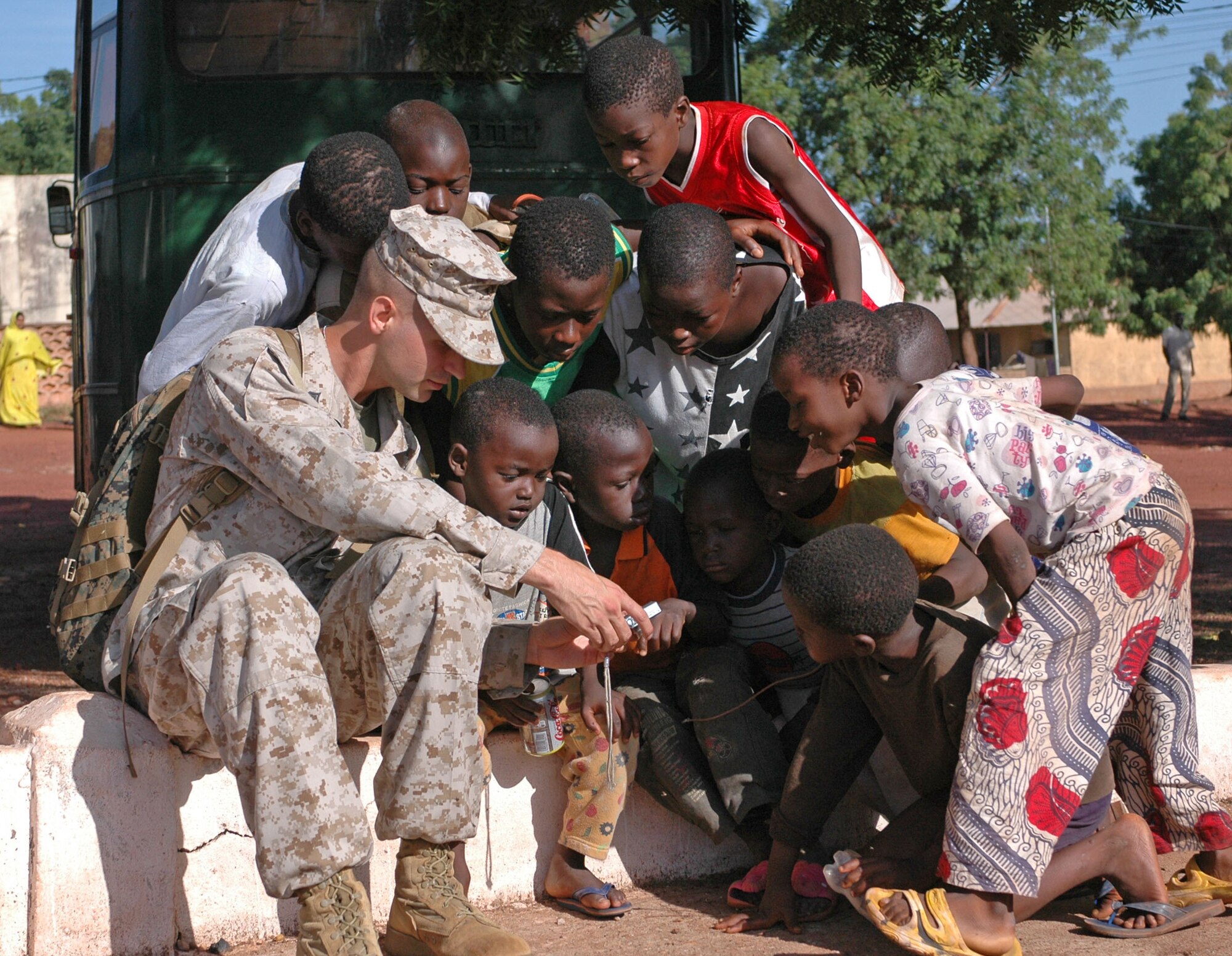 BAMAKO, Mali--Corporal Thomas Riseley, 3rd Civil Affairs, Camp Pendleton, Calif. shows Malian children some photos on his digital camera July 14, 2008 outside of Bamako, Mali. More than 90 servicemembers deployed to Bamako, July 11, for MEDFLAG 08, a multi-national medical training exercise designed to enhance medical capabilities and readiness for U.S. and African forces. (U.S. Air Force photo by Senior Airman Justin Weaver)