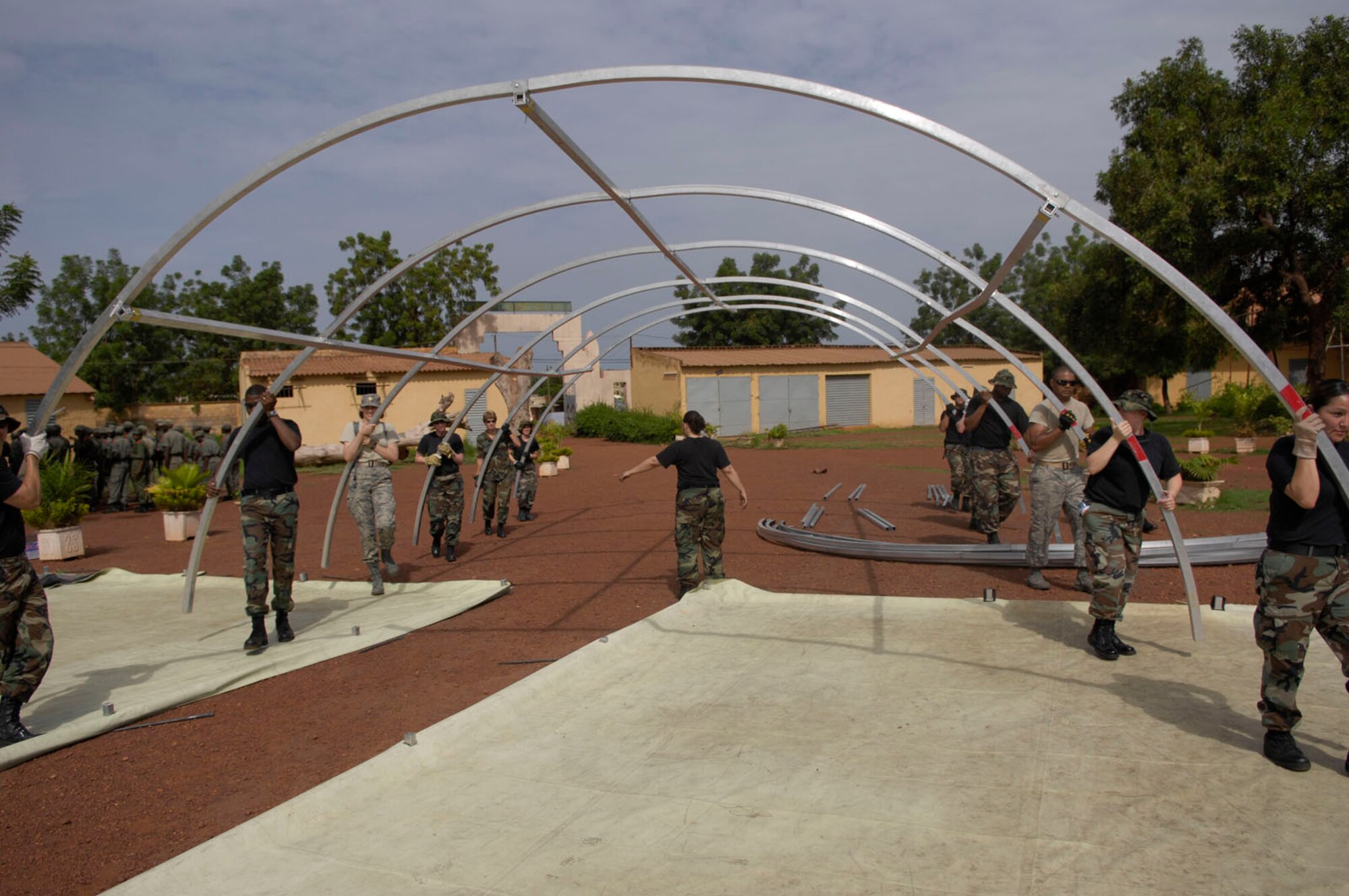 BAMAKO, Mali -- Medical personnel deployed in support of MEDFLAG 08 erect the frame for a tent while setting up an Expeditionary Medical Support unit, July 13, 2008.  More than 90 servicemembers deployed to Bamako, Mali, July 11, 2008, for MEDFLAG 08, a multi-national medical training exercise designed to enhance medical capabilities and readiness for U.S. and African Forces.  (U.S. Air Force photo/Senior Airman Michael S. Dorus)
