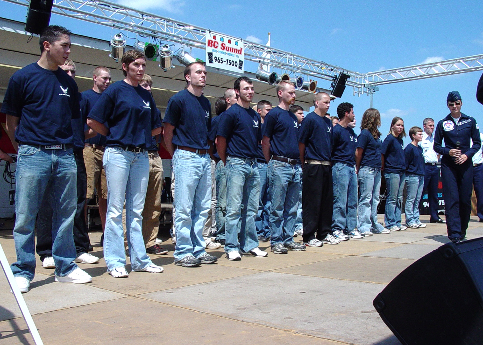 Capt. Elizabeth Kreft, U.S. Air Force Thunderbirds public affairs, prepares the stage for a 339th Recruiting Squadron Delayed Entry Program swear in ceremony for future Airmen on July 4th weekend at the Battle Creek Field of Flight Air Show and Balloon Festival in Michigan. Thunderbirds pilot Lt. Col. Rob Skelton, not shown, delivered the oath. (U.S. Air Force photo/Master Sgt. Michael McMillen)