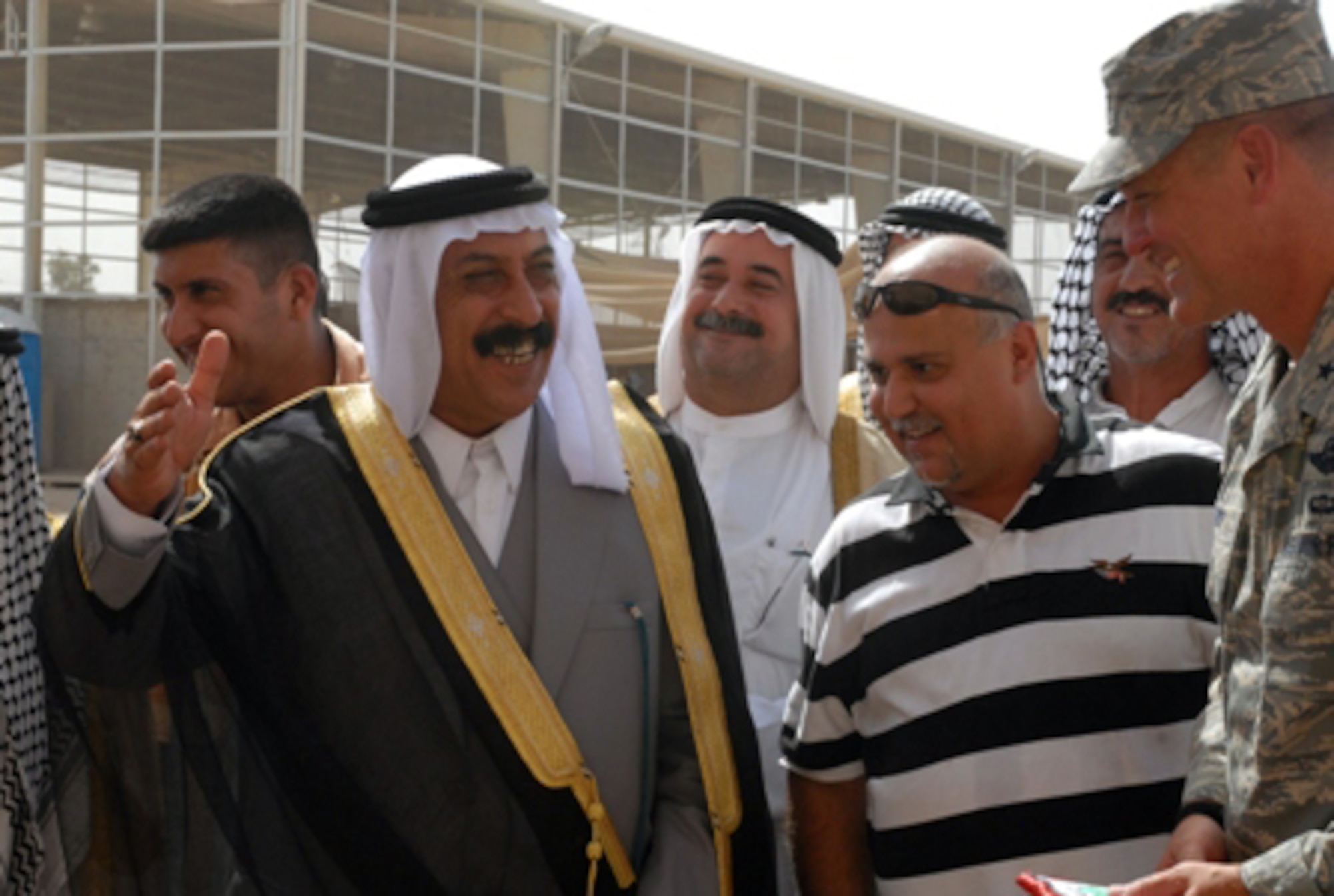 JOINT BASE BALAD, Iraq -- Sheikh Saad Hasan Altememy, a local leader near Balad, Iraq, confers with Brig. Gen. Brian Bishop during a ribbon-cutting ceremony for an Iraqi-run recycling center here July 11. The recycling center will provide 30 jobs to local Iraqis and assist current efforts to sort through daily garbage collection on base for recyclables. The recyclables will then be shipped off base and sold for profit on the Iraqi market. General Bishop is the 332nd Air Expeditionary Wing commander and installation commander. (U.S. Army photo/Sgt. Robert G. Cooper III)