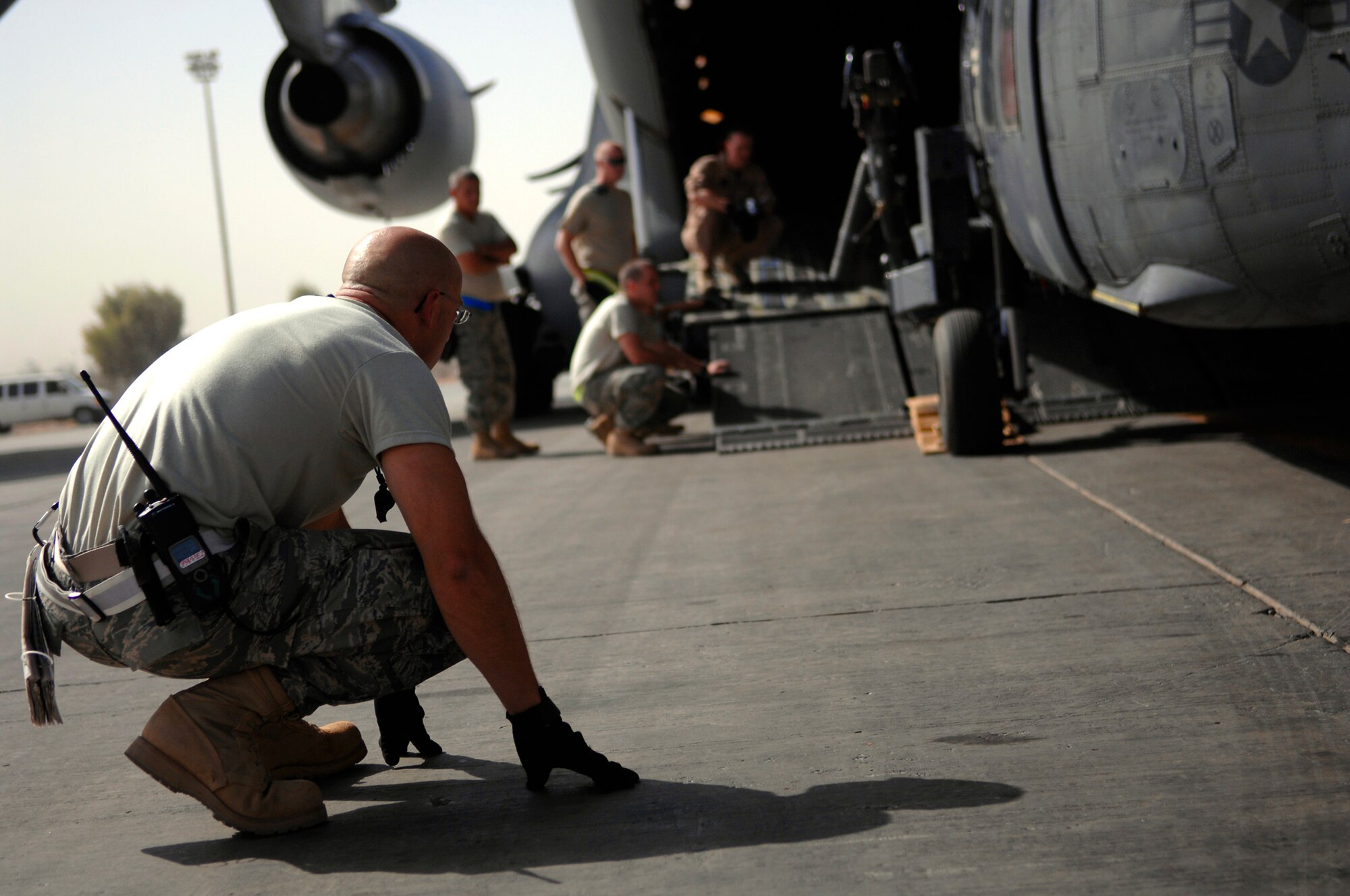 JOINT BASE BALAD, Iraq -- Tech. Sgt. Jason Lauer, 64th Expeditionary Helicopter Maintenance Unit crew chief, watches the underbelly on an HH-60 Pave Hawk while it's loaded onto a C-17 Globemaster III here July 12. A winch system on the C-17 is hooked to the helicopter and slowly drags it into the ramp. Sergeant Lauer is deployed from Davis-Monthan Air Force Base, Ariz. (U.S. Air Force photo/Senior Airman Julianne Showalter)