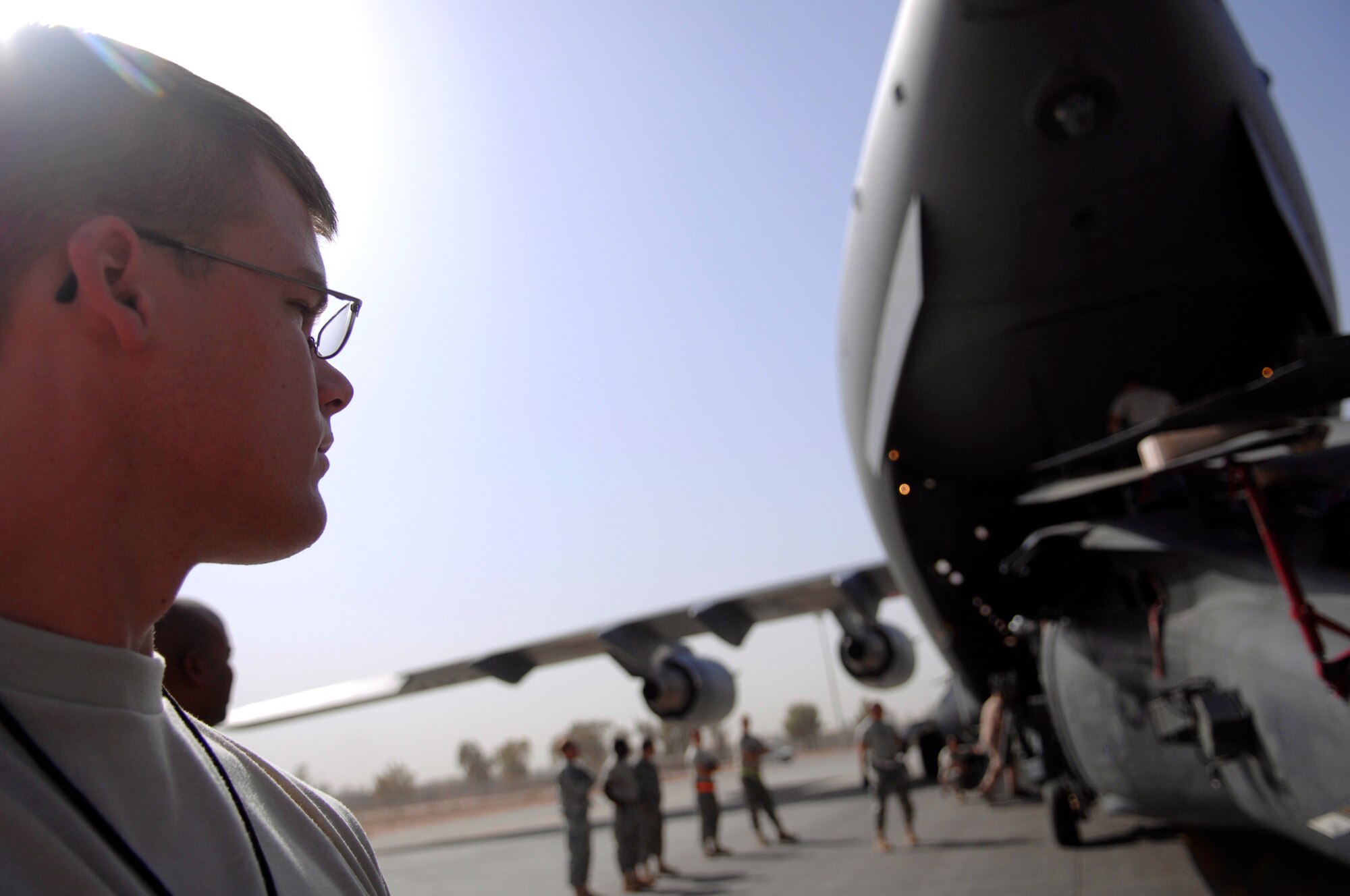 JOINT BASE BALAD, Iraq -- Airman 1st Class John Rhoades, 64th Expeditionary Helicopter Maintenance Unit avionics specialist, stands by as an HH-60 Pave Hawk is loaded onto a C-17 Globemaster III here July 12. Several Airmen position themselves around the helicopter to ensure it doesn't make contact and cause damage. The helicopter is being rotated back to Moody Air Force Base, Ga., for overhaul maintenance. Airman Rhoades is deployed from Davis-Monthan Air Force Base, Ariz. (U.S. Air Force photo/Senior Airman Julianne Showalter) 