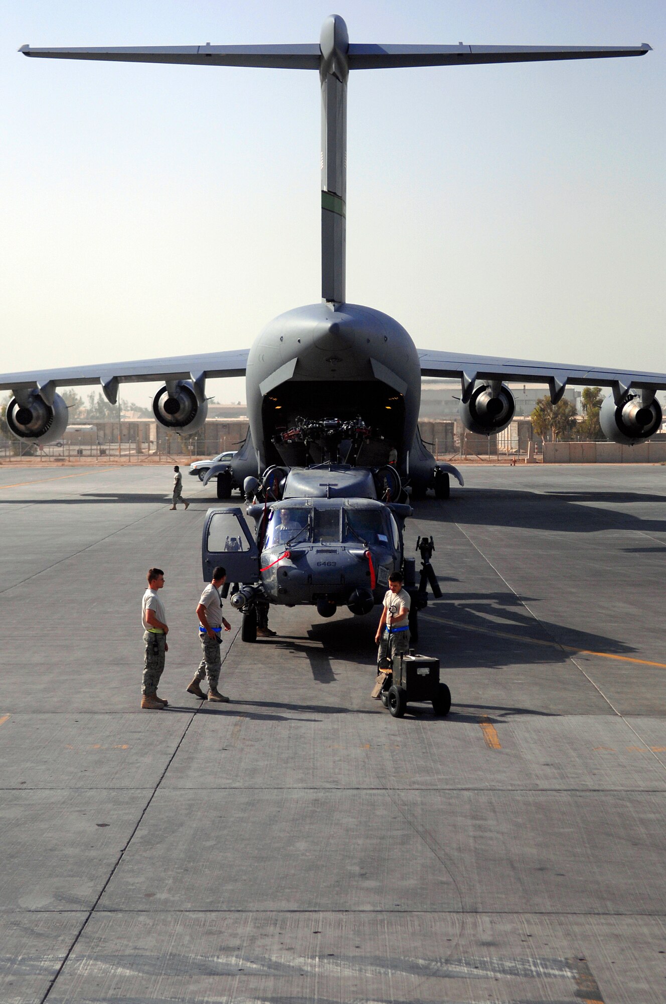 JOINT BASE BALAD, Iraq -- Airmen assigned to the 64th Expeditionary Helicopter Maintenance Unit prepare an HH-60 Pave Hawk for loading onto a C-17 Globemaster III here July 12. The helicopter is in a folded configuration in order to fit into the hull of the aircraft. The Airmen assigned are deployed from Davis-Monthan Air Force Base, Ariz. (U.S. Air Force photo/Senior Airman Julianne Showalter) 