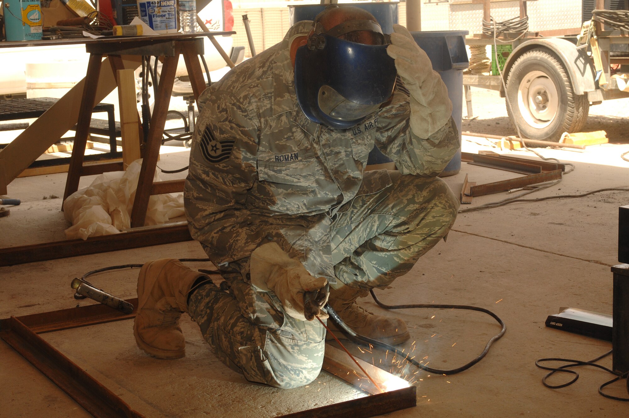 SOUTHWEST ASIA -- Sparks fly as Tech. Sgt. Anthony Roman, deployed to the 386th Expeditionary Civil Engineer Squadron, uses an arc welder to join a frame together on July 11 at a base in Southwest Asia. The 386th ECES is completing a project to increase the square footage of the K-9 kennels for the 386th Expeditionary Security Forces Squadron. The metal frames will be used to build new ramps for the facility. Sergeant Roman is deployed from the 156th Airlift Wing, Muniz Air National Guard Base, Puerto Rico. (U.S. Air Force photo/Tech. Sgt. Raheem Moore)
