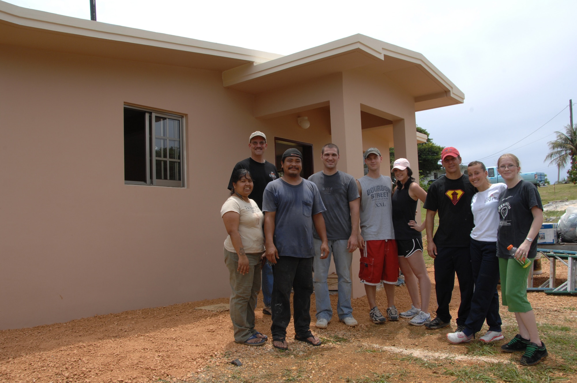 Volunteers from the 36th Operations Support Squadron pause from their construction efforts with the Habitat for Humanity July 11to stand in front of a newly renovated home Yona, Guam, with the family that will acquire it.  Habitat for Humanity is a program that provides homes for local families that are in need. (U.S. Air Force photo by Airman 1st Class Courtney Witt)