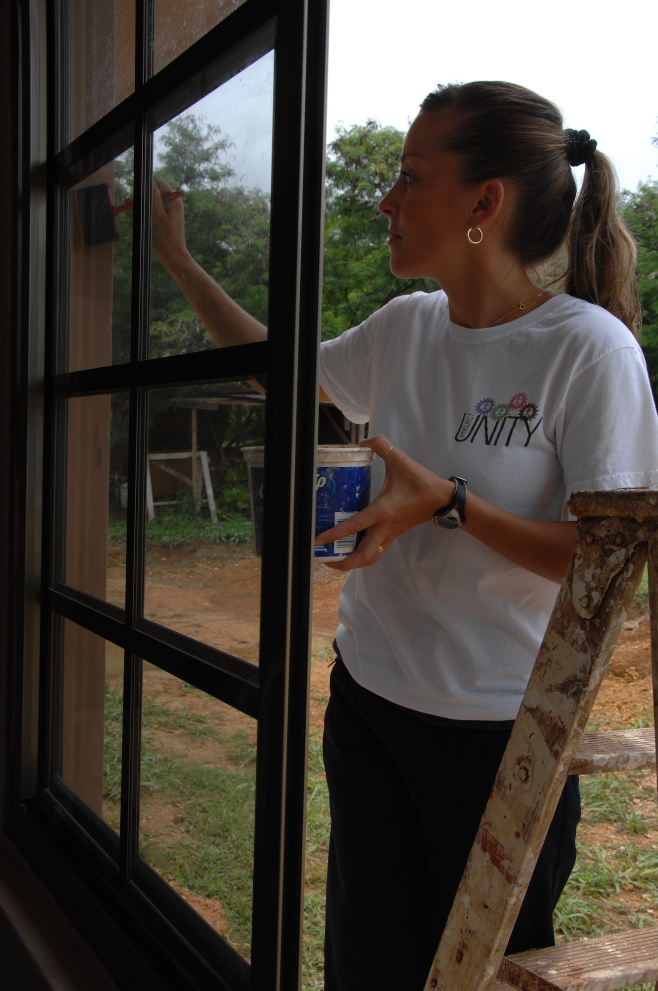 Noemie Neipert, wife of Tech. Sgt. Les Neipert, 36th Operations Support Squadron, paints a window sill during a volunteer mission for Habitat for Humanity in Yona, Guam, July 11.  Habitat for Humanity is a program that provides homes for local families that are in need. The family that will be living in this new house also helped out with the 36th OSS Squadron volunteers. (U.S. Air Force photo by Airman 1st Class Courtney Witt)