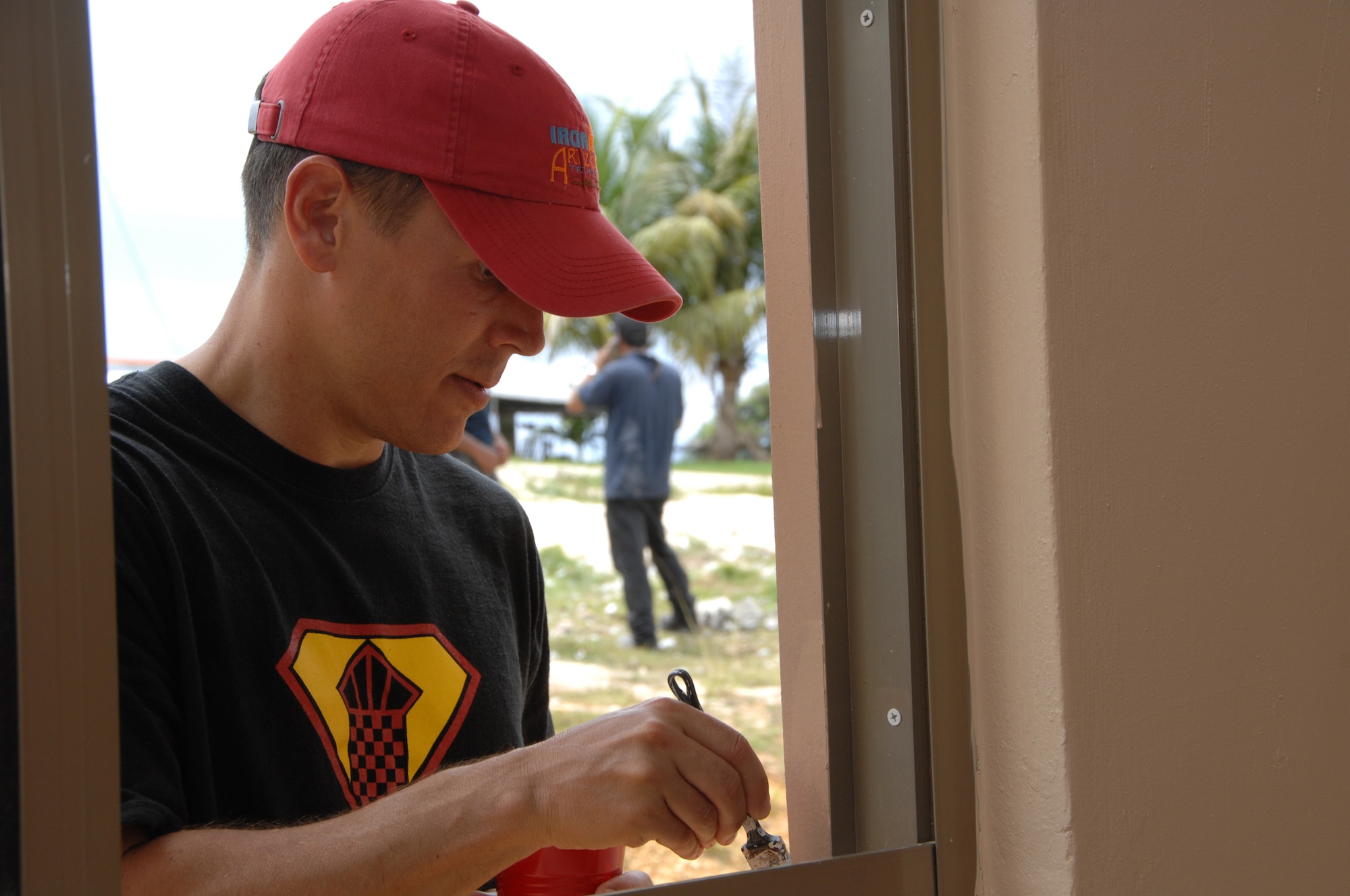 U.S. Air Force Tech. Sgt. Les Neipert of the 36th Operations Support Squadron paints a window sill during a volunteer mission for Habitat for Humanity in Yona July 11.  Habitat for Humanity is a program that provides homes for local families that are in need. The family that will be living in this new house also helped out with the 36th OSS volunteeers. (U.S. Air Force photo by Airman 1st Class Courtney Witt)