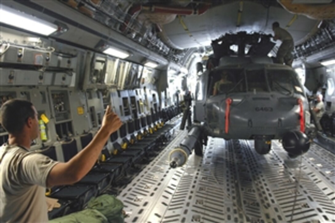 U.S. Air Force Tech. Sgt. Joseph Herrera gives a thumbs-up to other crew chiefs and loadmasters as a winch system drags an HH-60 Pave Hawk helicopter onto a C-17 Globemaster III aircraft on Joint Base Balad, Iraq, July 12, 2008. Herrera, a crew chief with the 64th Expeditionary Helicopter Maintenance Unit, deployed from Davis-Monthan Air Force Base, Ariz.  