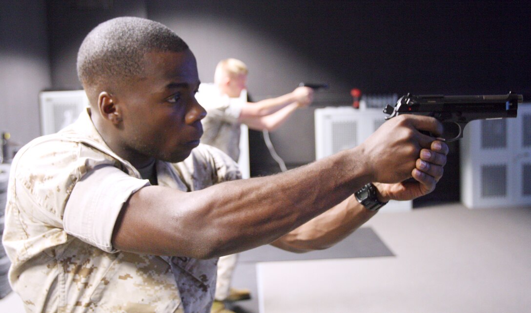 Cpl. Moncelly Fuller, fiscal clerk, fires at simulated targets at an Indoor Simulated Marksmanship Trainer at Marine Barracks, Washington, July 14.