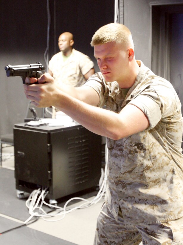 Lance Cpl. Mark A. Lucado, fiscal clerk, fires on simulated targets at an Indoor Simulated Marksmanship Trainer at Marine Barracks, Washington, July 14.