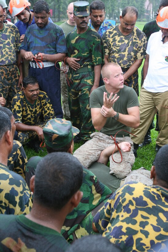 Sgt. Wesley Wallace teaches cuffing procedures to Bangladesh service members and local law-enforcement personnel July 15 during Non-Lethal Weapons Executive Seminar 2008 here. Wallace is an anti-terrorism force protection instructor with Maine Corps Base Camp Butler's Provost Marshal's Office.