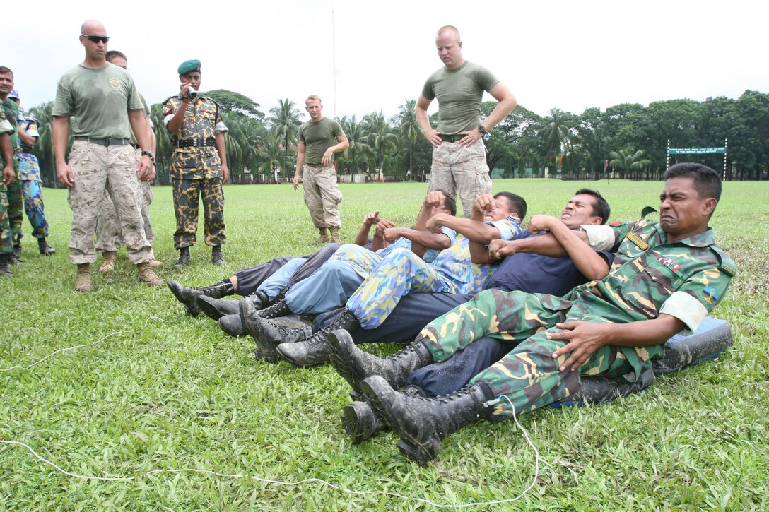 Bangladesh service members and local law-enforcement personnel cringe in pain as they experience the effects of a X26E electro-muscular disrupter (stun gun)  July 15 during Non-Lethal Weapons Executive Seminar 2008 here.