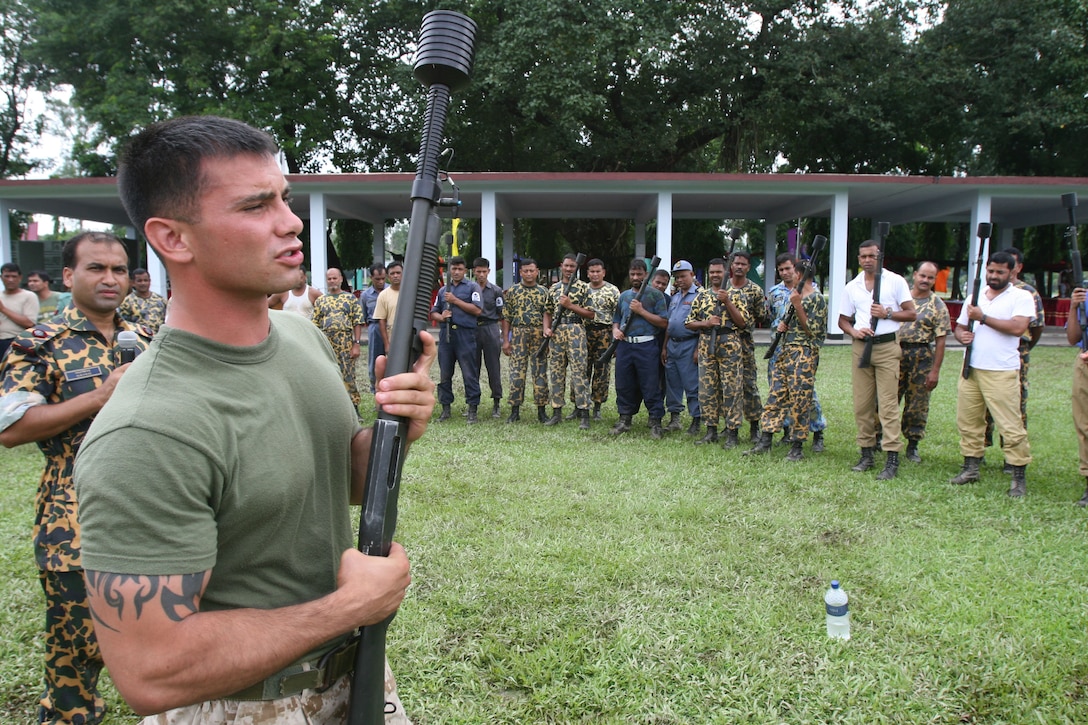 Sgt. Corey Gonzalez gives a 12 Gauge Mossberg 500A2 shotgun class to Bangladesh service members and local law-enforcement personnel July 15 during Non-Lethal Weapons Executive Seminar 2008 here. Gonzalez is an assistant anti-terrorism force protection instructor with III Marine Expeditionary Force's Special Operations Training Group. The shotgun can be loded with lethal and non-lethal rounds.