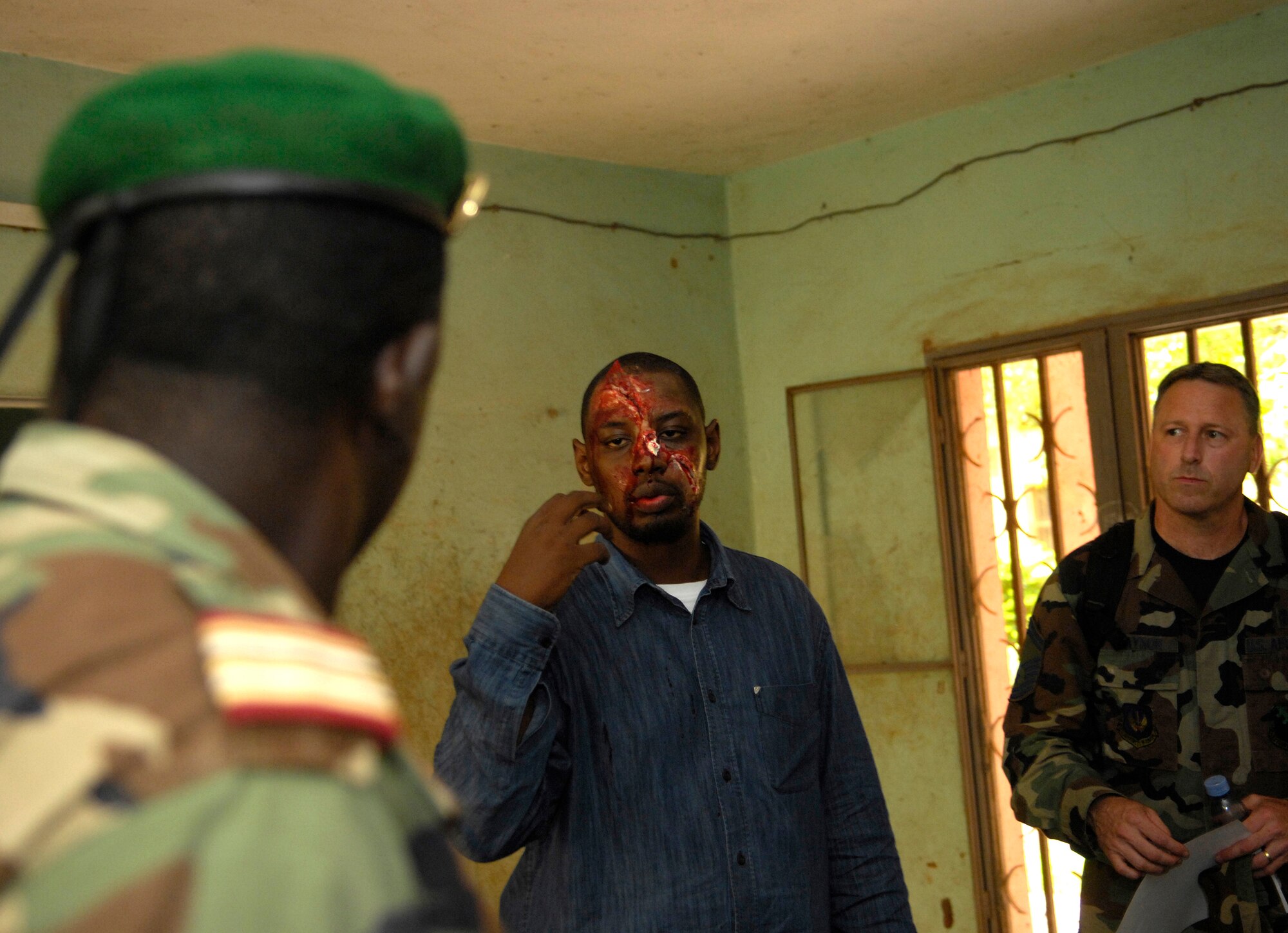 BAMAKO, Mali -- Mohamed Diawara translates for Senior Master Sgt. Robert Traynor while talking to members of the Malian military about the moulage make-up Mr. Diawara is wearing during MEDFLAG 08, July 15, 2008.  More than 90 servicemembers deployed to Bamako for MEDFLAG 08, a multi-national medical training exercise designed to enhance medical capabilities and readiness for U.S. and African Forces.  Sergeant Traynor is deployed from the 31st Medical Group, Aviano Air Base, Italy.  (U.S. Air Force photo/Senior Airman Michael S. Dorus)
