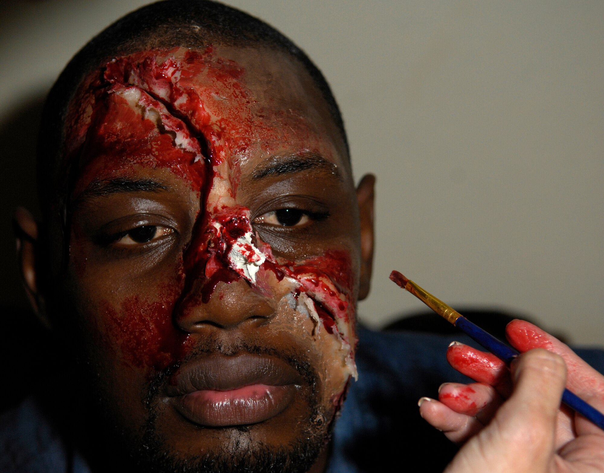 BAMAKO, Mali -- Staff Sgt. Michelle Linn applies moulage make-up to Mohamed Diawara, a Malian translator, during MEDFLAG 08, July 15, 2008.  More than 90 servicemembers deployed to Bamako for MEDFLAG 08, a multi-national medical training exercise designed to enhance medical capabilities and readiness for U.S. and African Forces.  Sergeant Linn is deployed from the 48th Medical Group at Royal Air Force Lakenheath, England.  (U.S. Air Force photo/Senior Airman Michael S. Dorus)